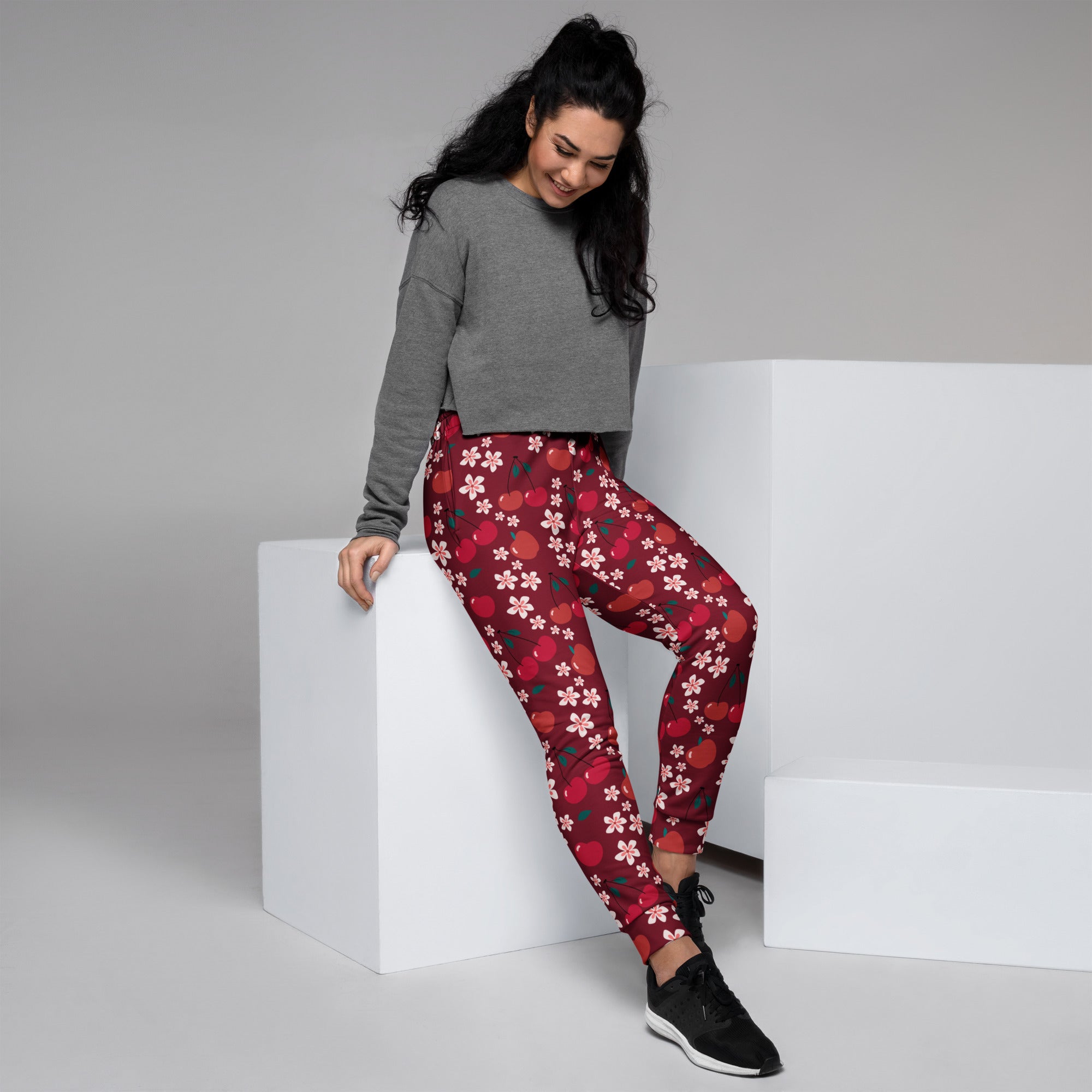 Women’s red recycled jogger pants with cozy fleece inside and white cherry blossom and red apple pattern