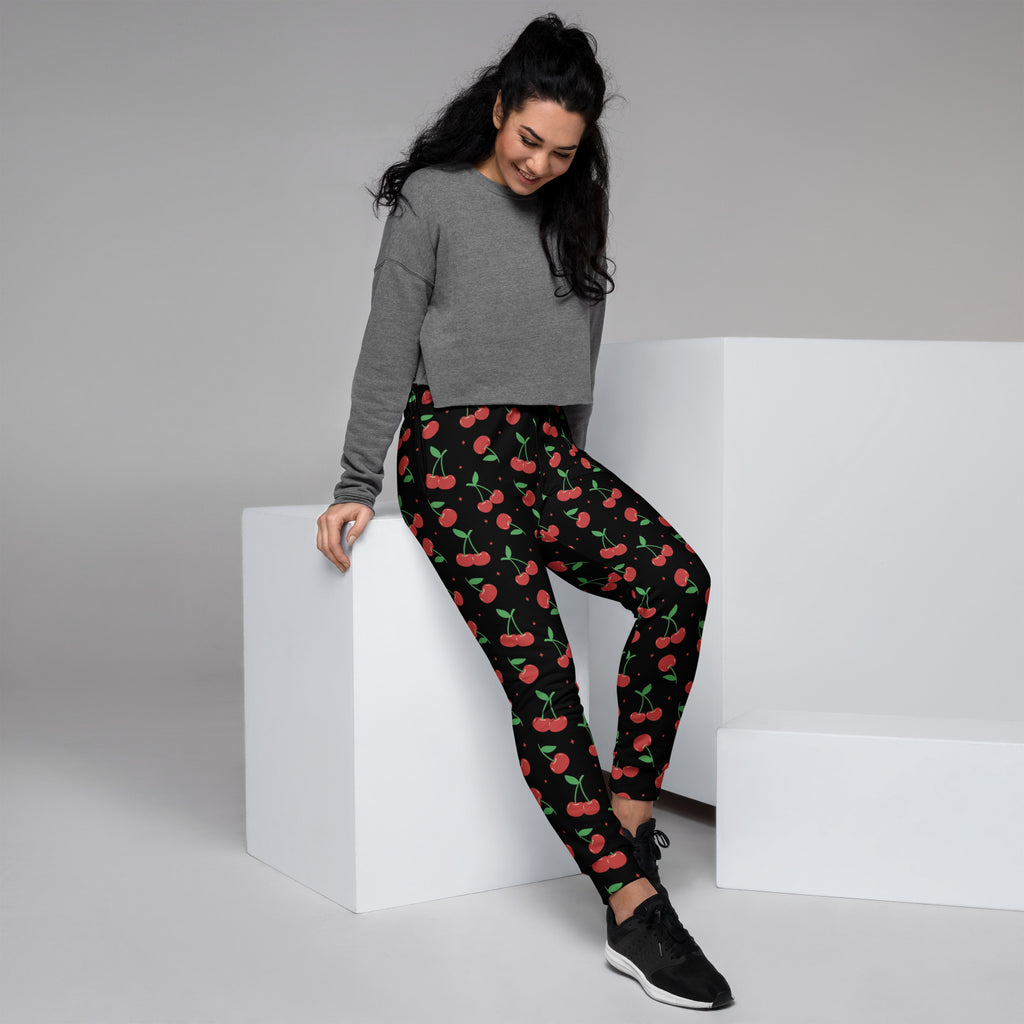 Women’s black cherry recycled jogger pants with pockets featuring vibrant red cherry pattern and cozy brushed fleece lining