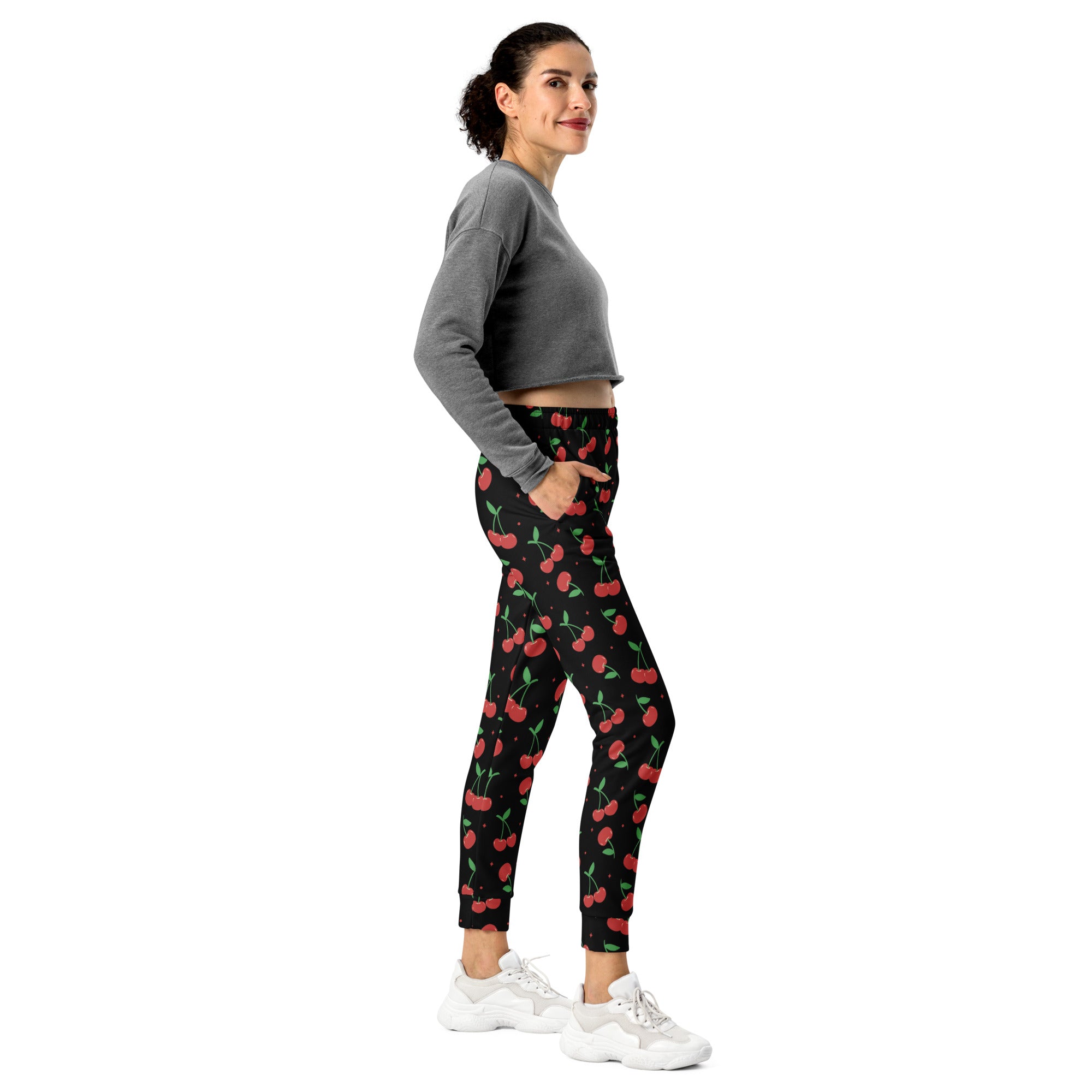 Women’s black cherry recycled jogger pants with pockets feature vibrant red cherry pattern and cozy brushed fleece lining