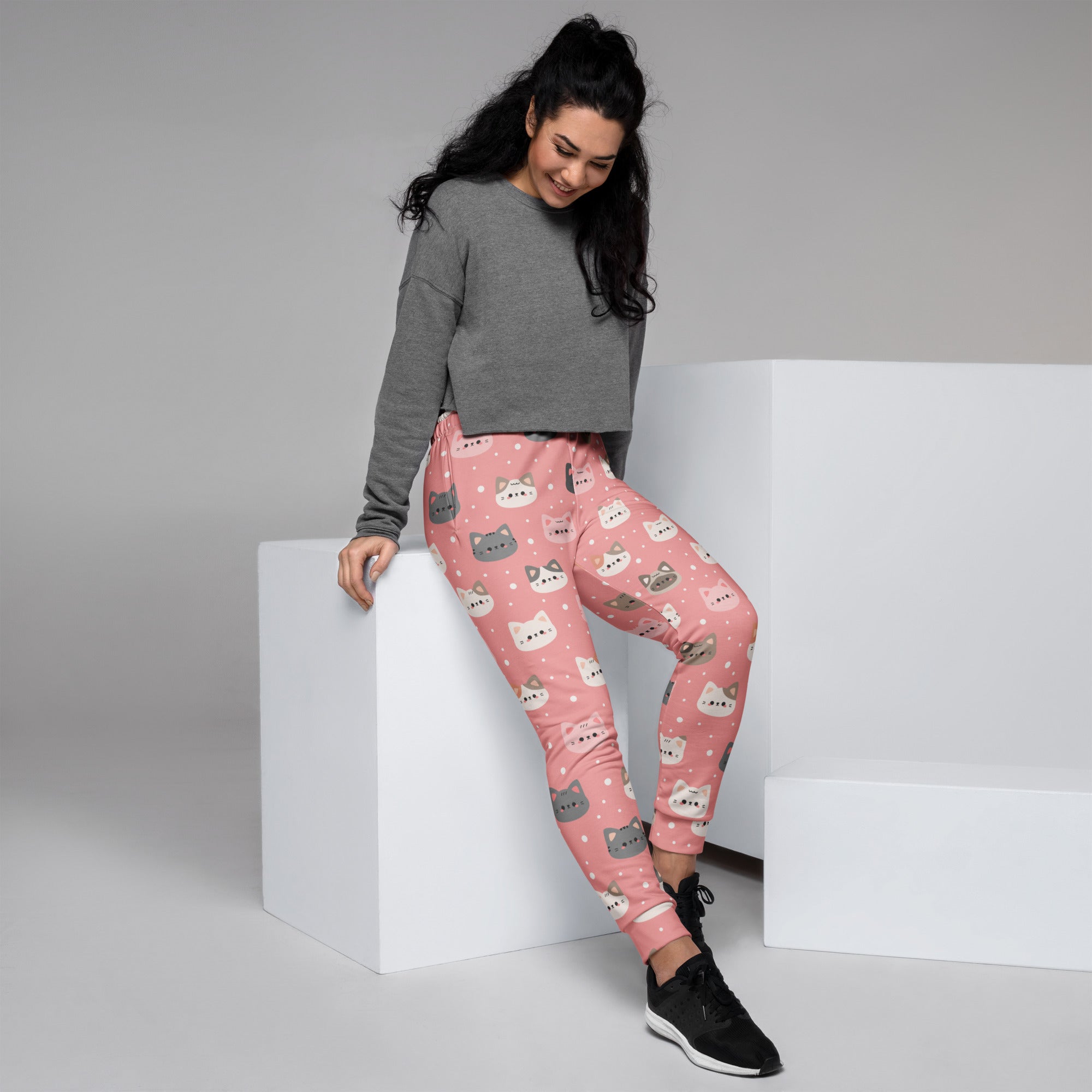 Women’s pink recycled jogger pants with cozy brushed fleece featuring playful gray and white cartoon cats and star accents