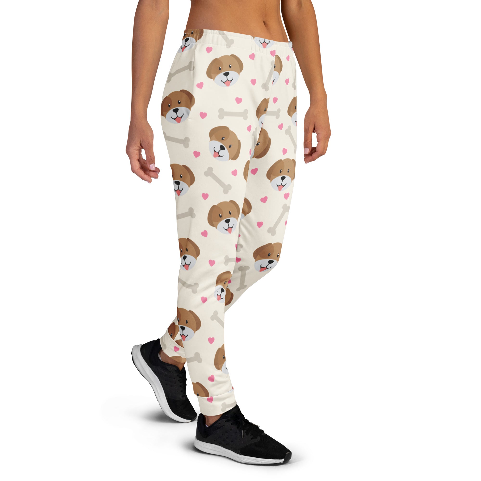 Cream-colored women’s jogger pants with playful brown puppy faces pink hearts white bones made from cozy recycled fleece
