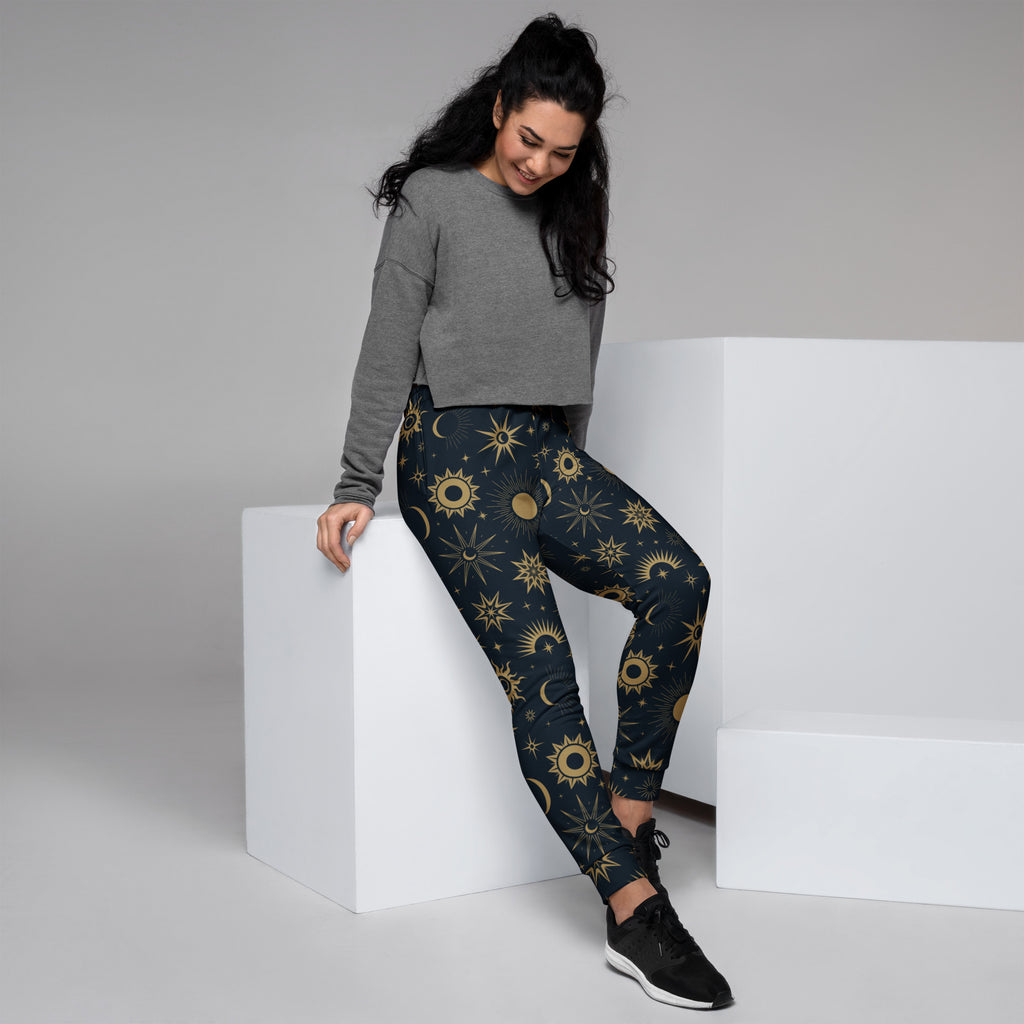 Dark blue women’s celestial sun and moon recycled jogger pants with vibrant gold pattern and cozy brushed fleece inside