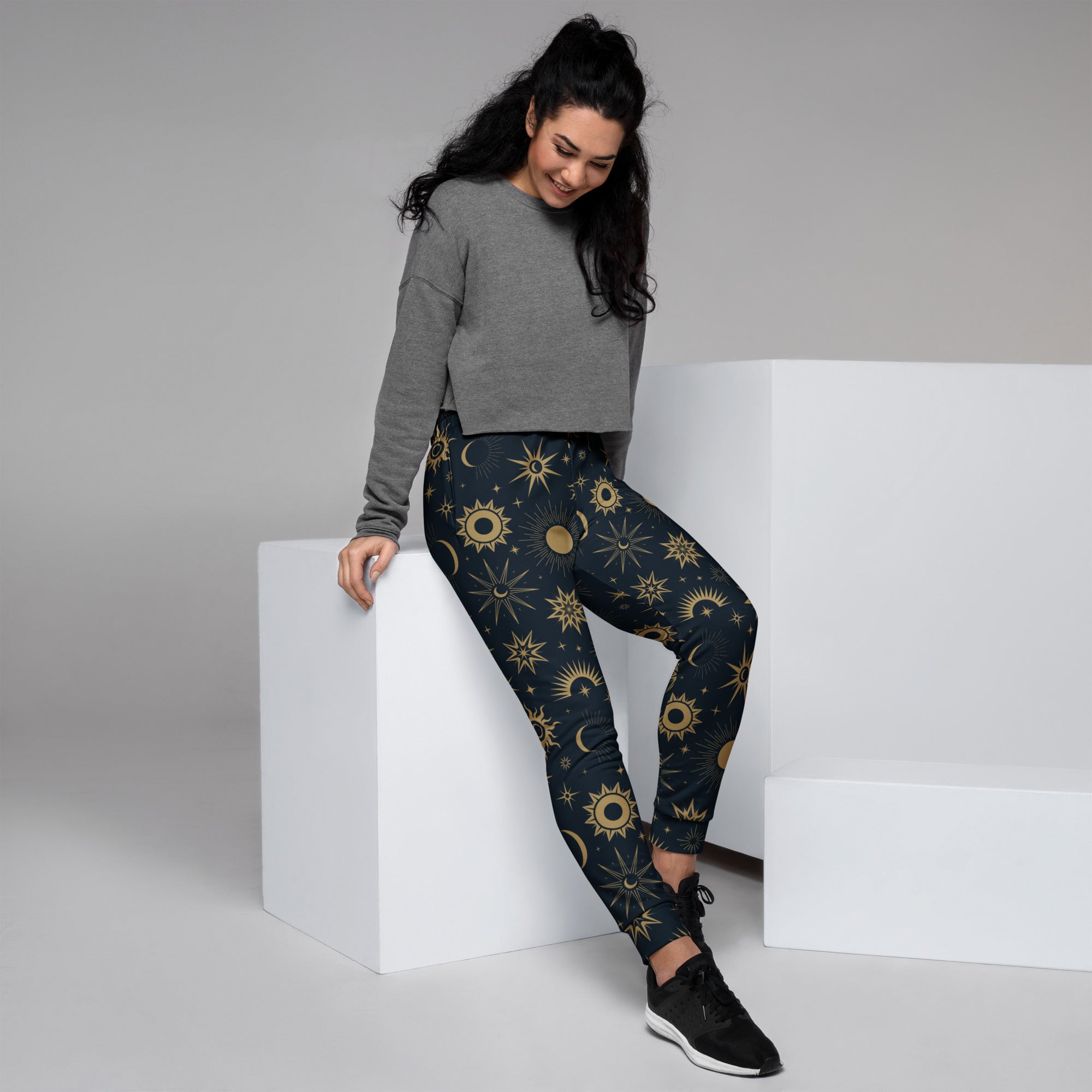 Dark blue women’s celestial sun and moon recycled jogger pants with vibrant gold pattern and cozy brushed fleece inside