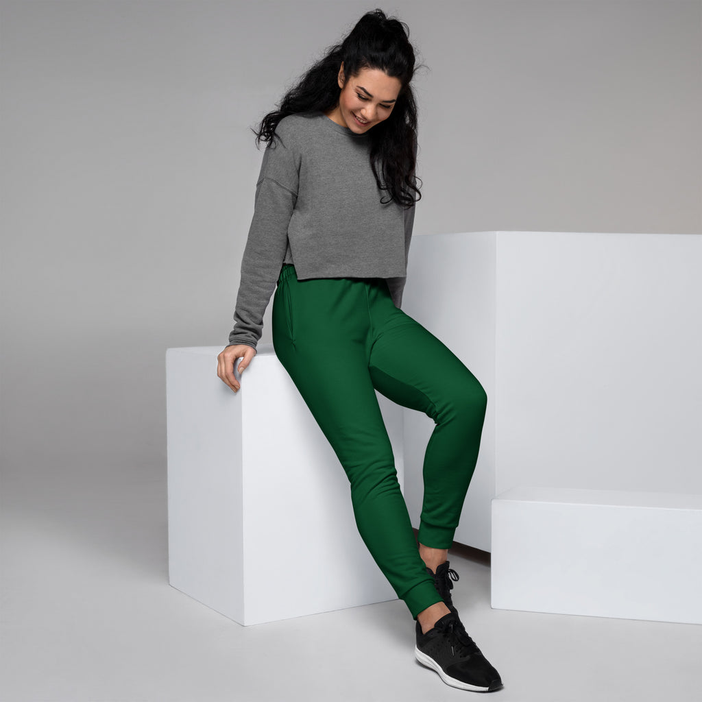 A pair of vibrant emerald green recycled jogger pants for women with ribbed cuffs and cozy brushed fleece lining