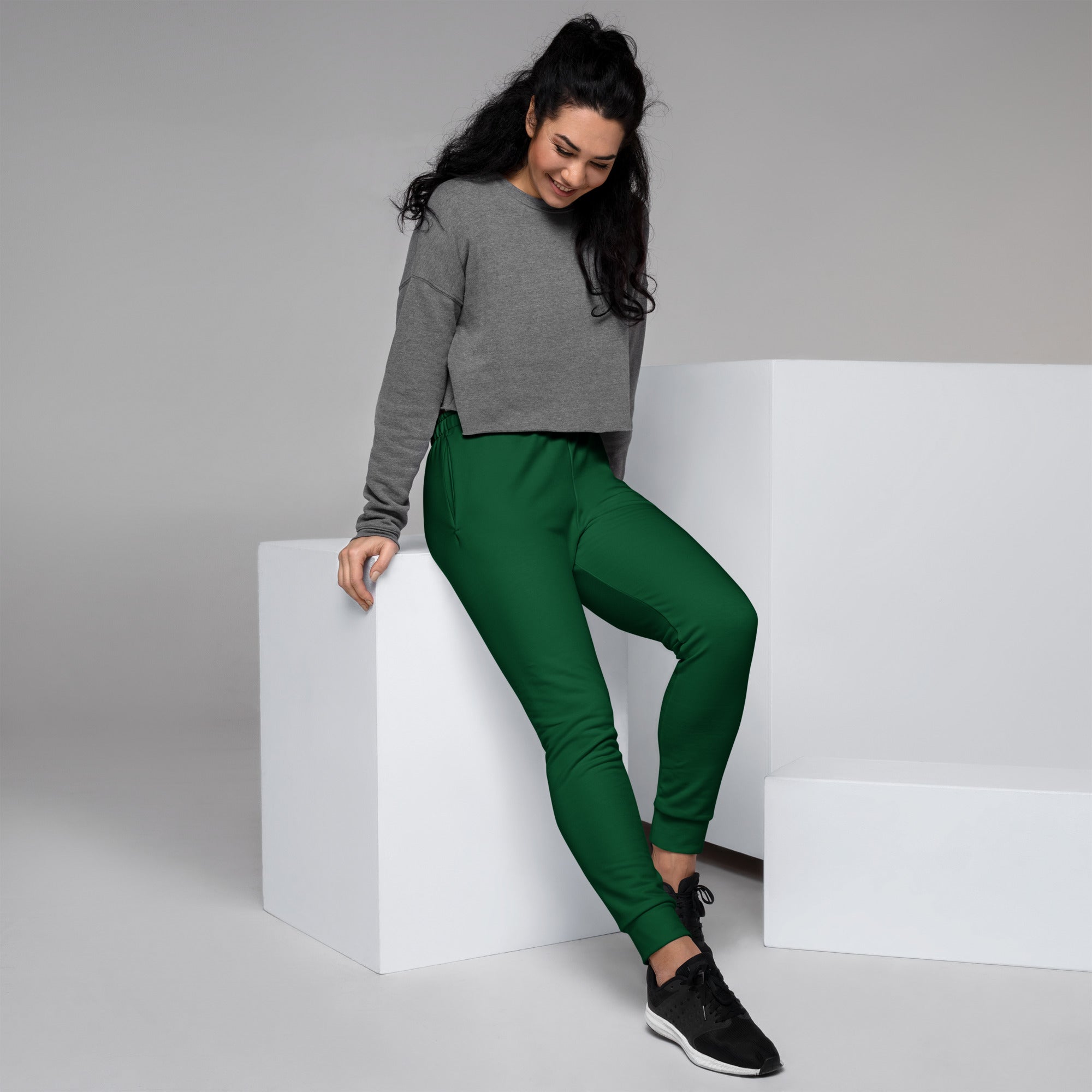 A pair of vibrant emerald green recycled jogger pants for women with ribbed cuffs and cozy brushed fleece lining