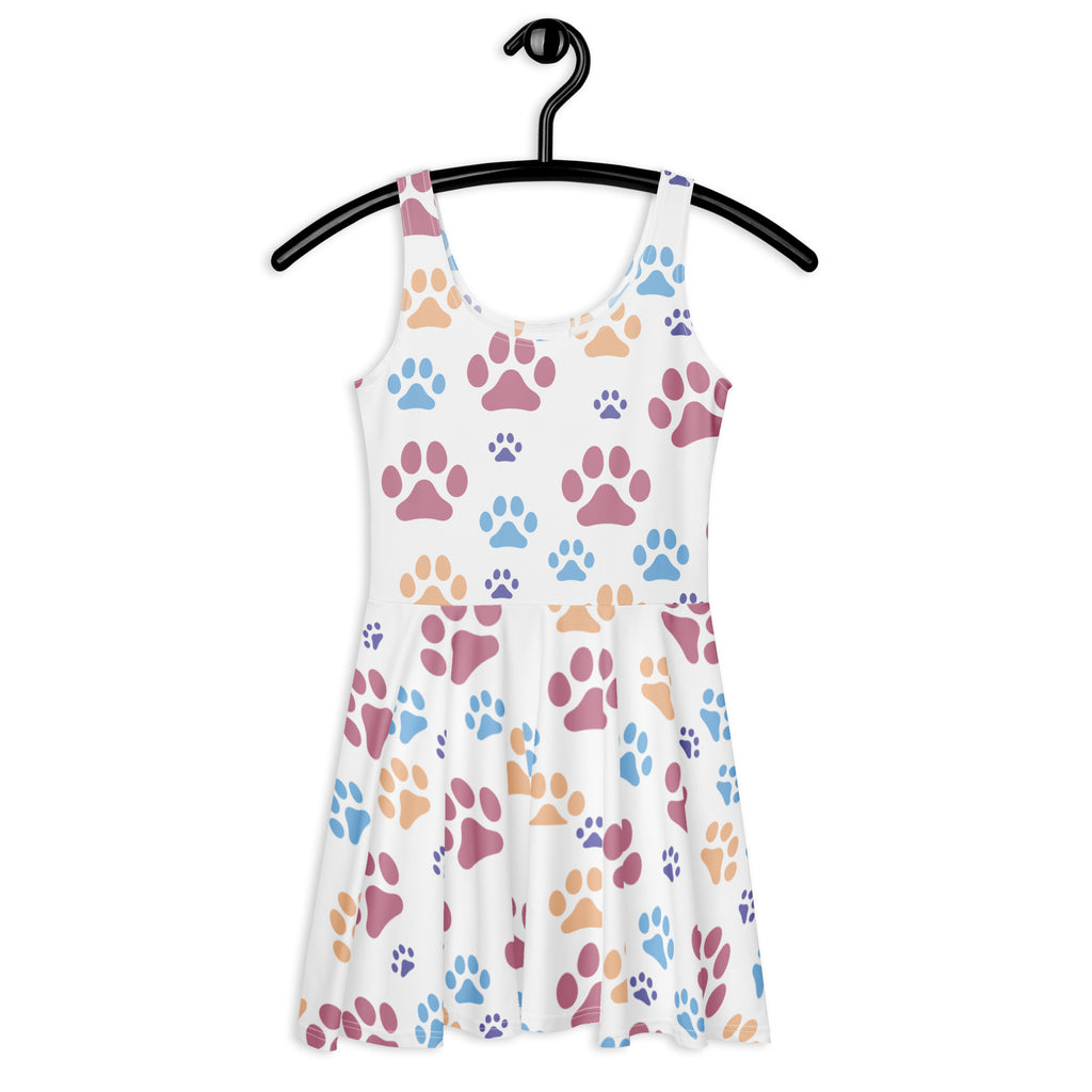 A white sleeveless buttery soft skater dress with colorful pink blue and tan paw prints and upf 50 plus protection