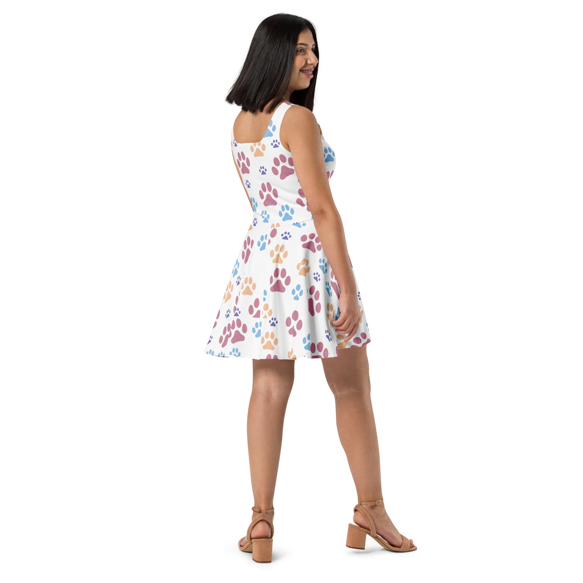White sleeveless buttery soft skater dress with colorful pink blue and tan paw prints and UPF 50 plus protection