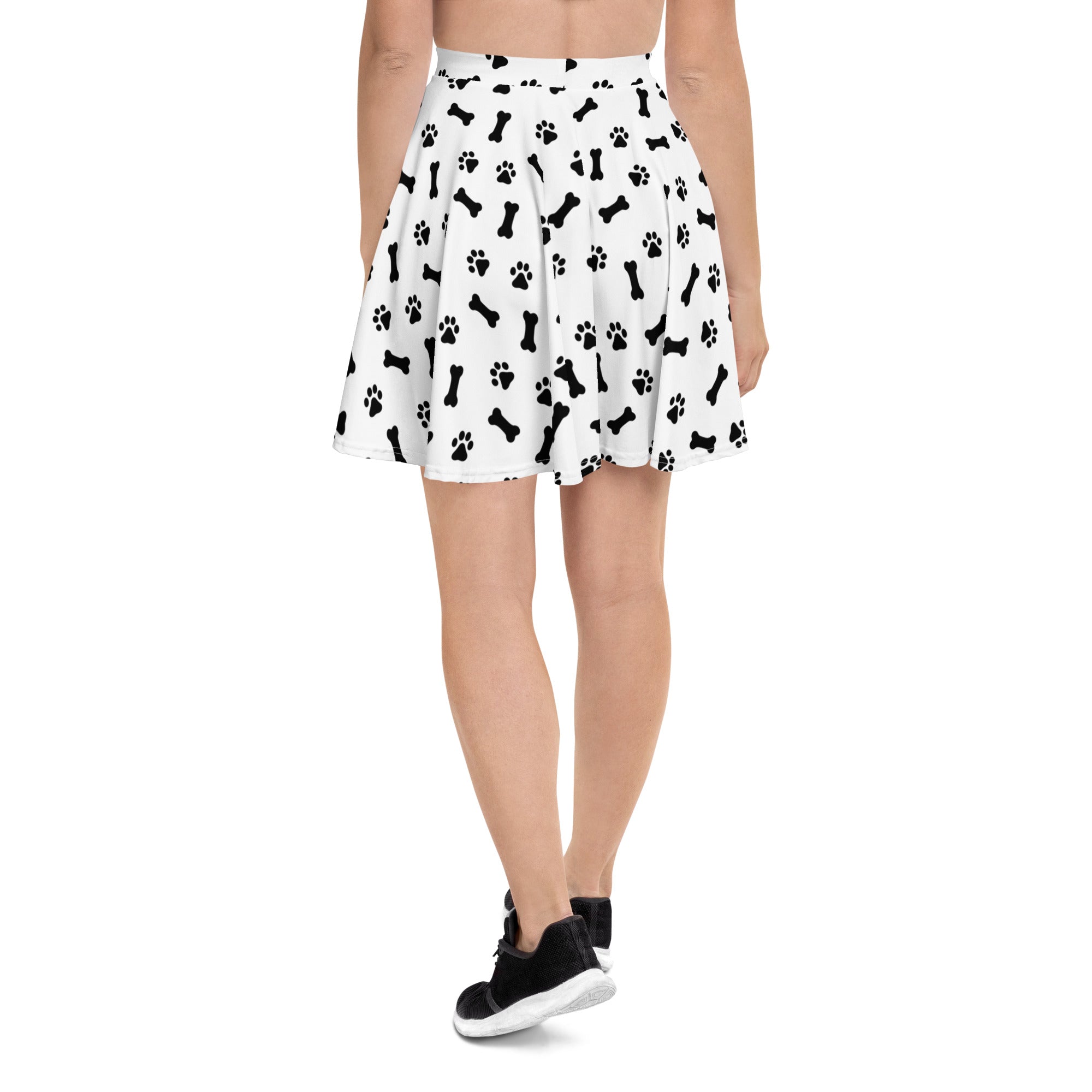 White pleated women’s skater skirt with black dog bone and paw print pattern made from recycled fabric with upf 50+