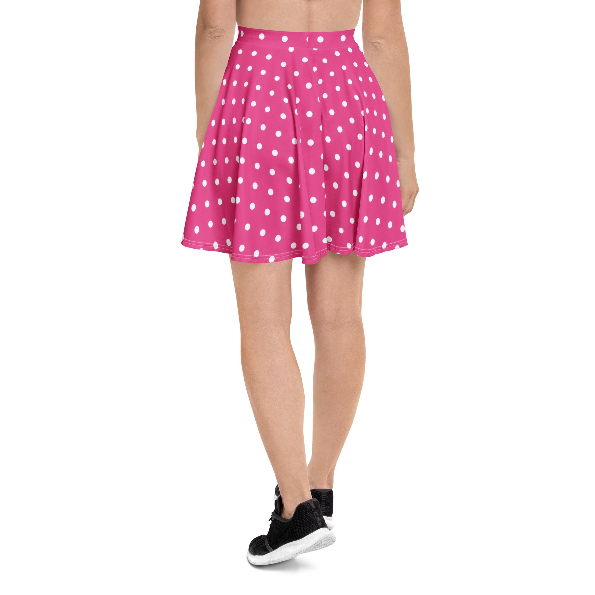 A vibrant pink pleated women’s skater skirt with white polka dots made from recycled fabric with UPF 50+ protection