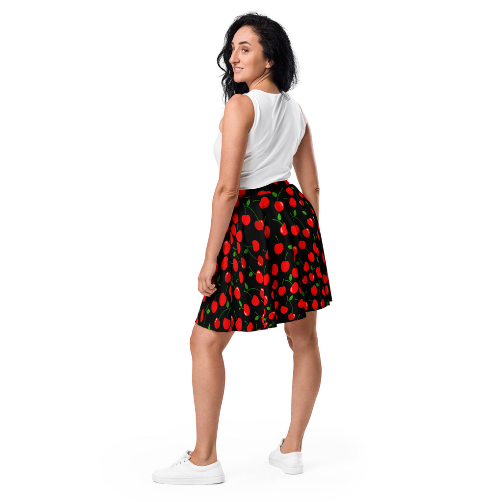 A woman wearing a women’s black cherry skater skirt with vibrant red cherry pattern high waisted and flowy with upf 50+