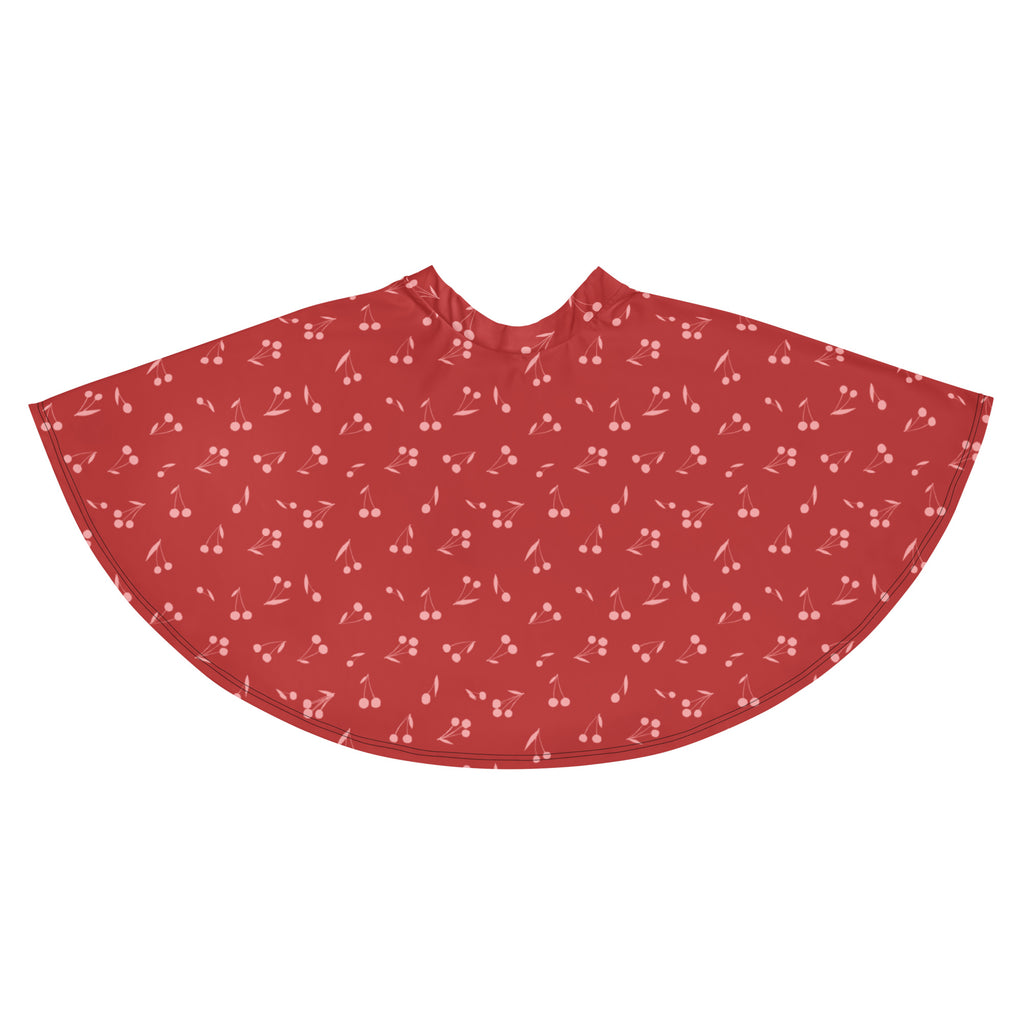 A flowy red cherry patterned cape in soft recycled fabric perfect for stylish layering and sun protection