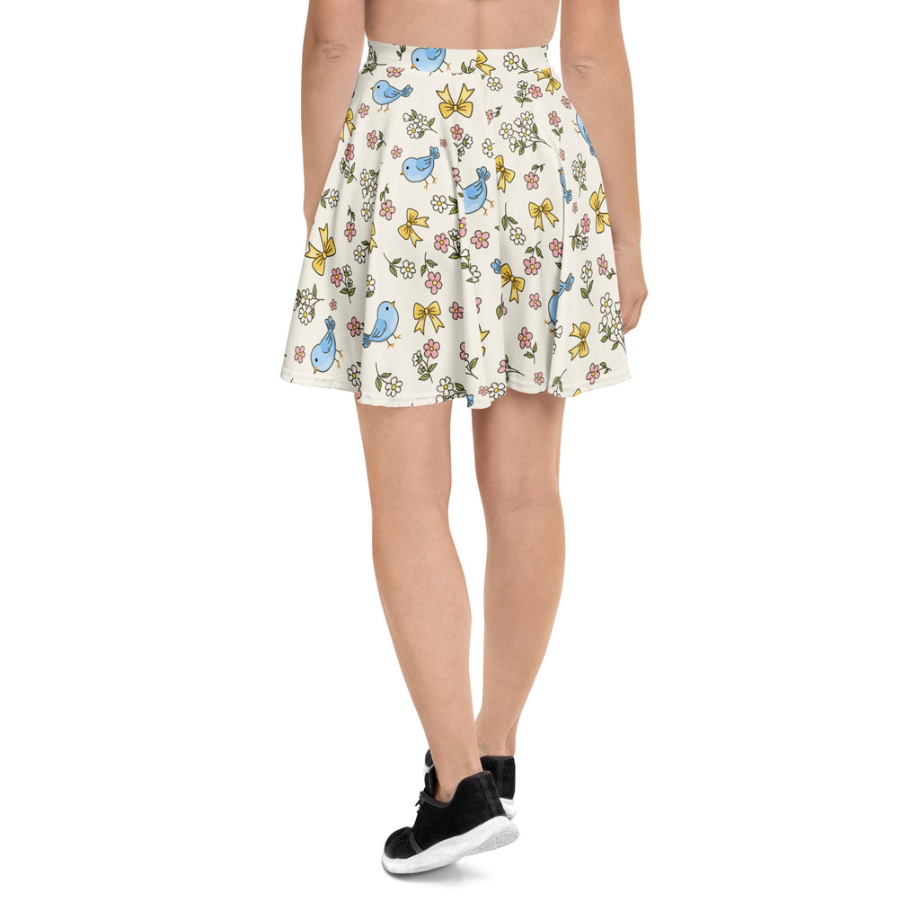A cream flared blue bird skater skirt with yellow bows pink flowers flowy high waisted recycled fabric and UPF 50+ protection