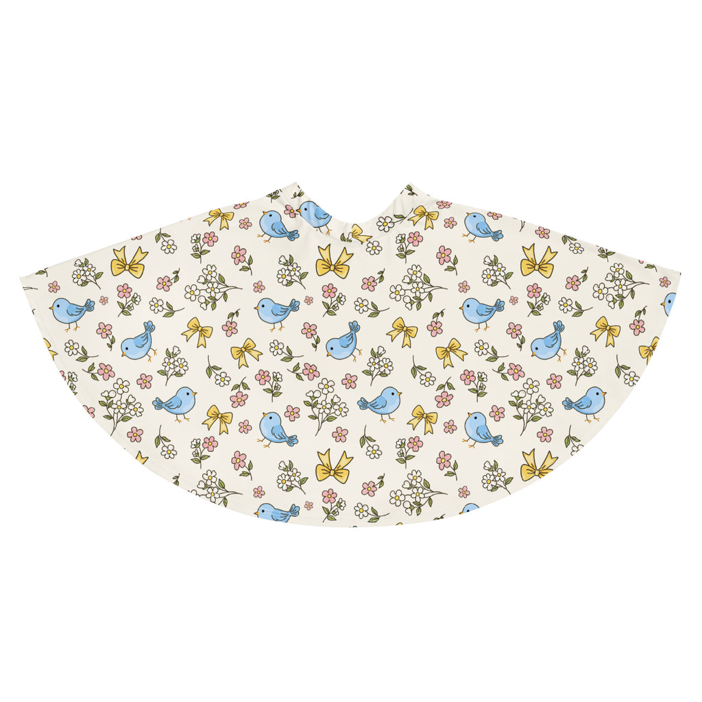 A charming off-white fabric cape with blue birds yellow bows and pink white flowers paired with a blue bird skater skirt