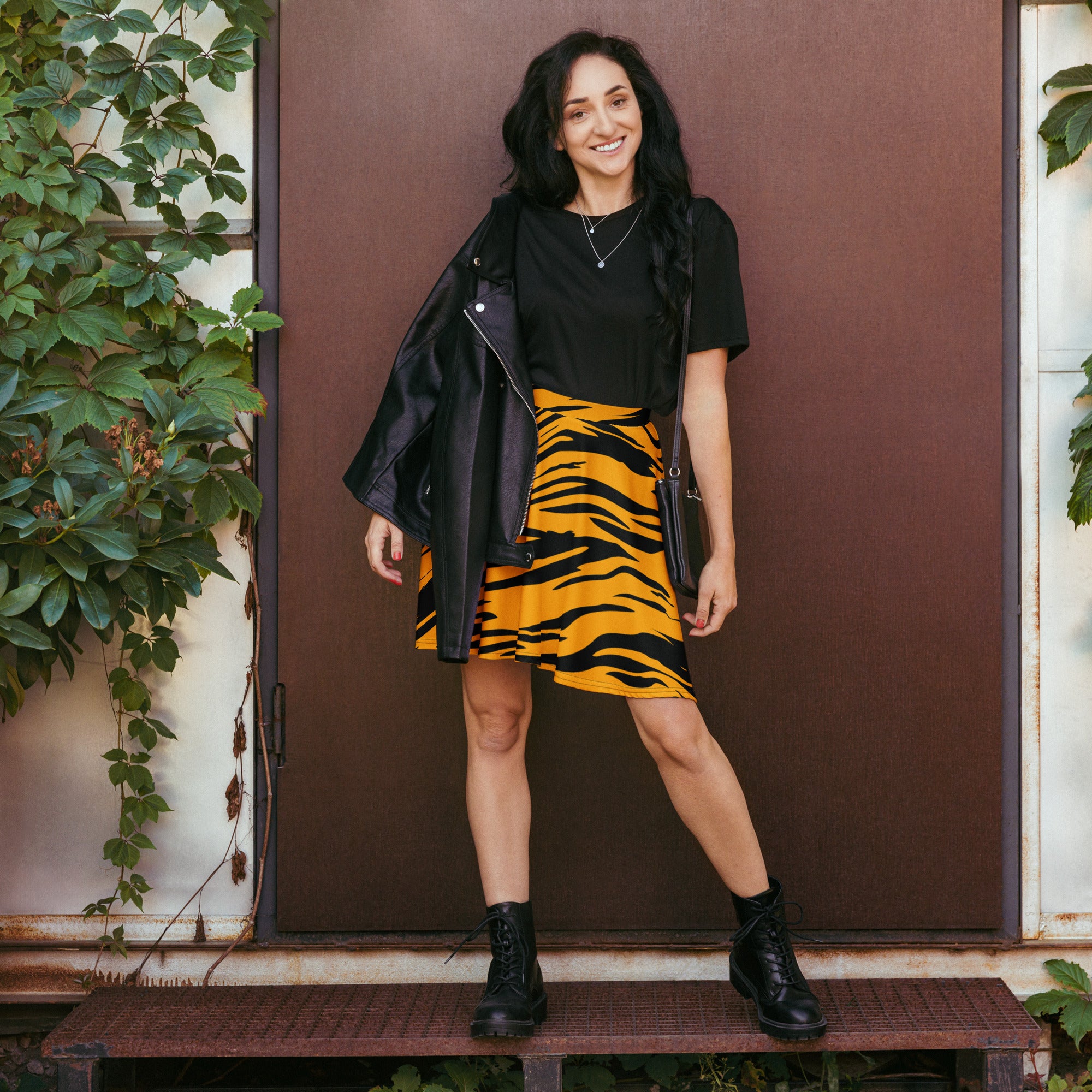Black leather jacket with zipper details paired with women’s tiger print skater skirt high waisted flowy fabric