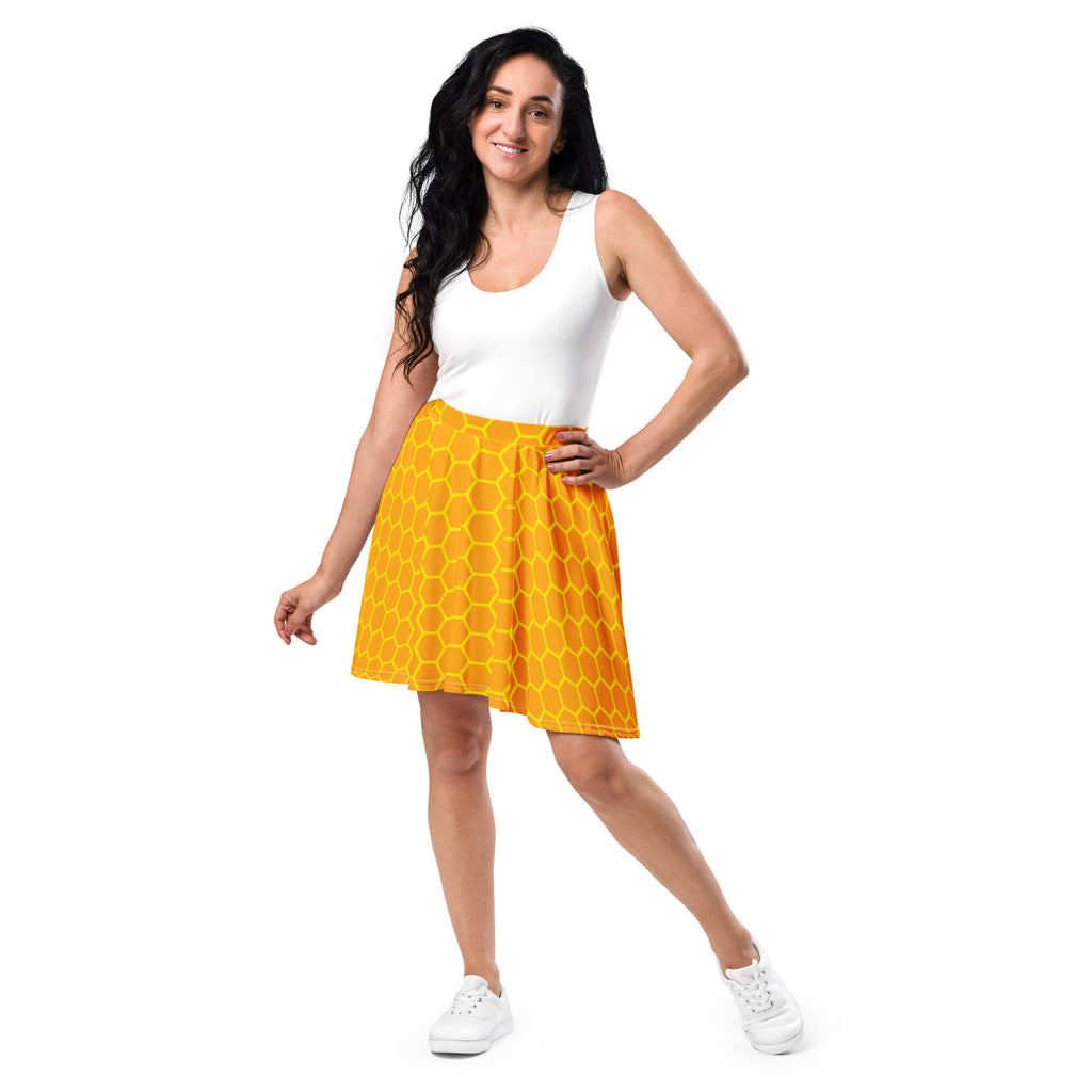 A vibrant yellow women’s honeycomb skater skirt made of recycled fabric with UPF 50+ and a bold pattern