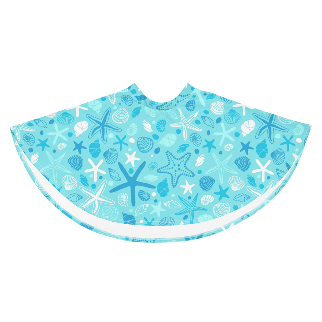 A light blue beach poncho with starfish and seashell patterns in blue white and gray made from recycled fabric