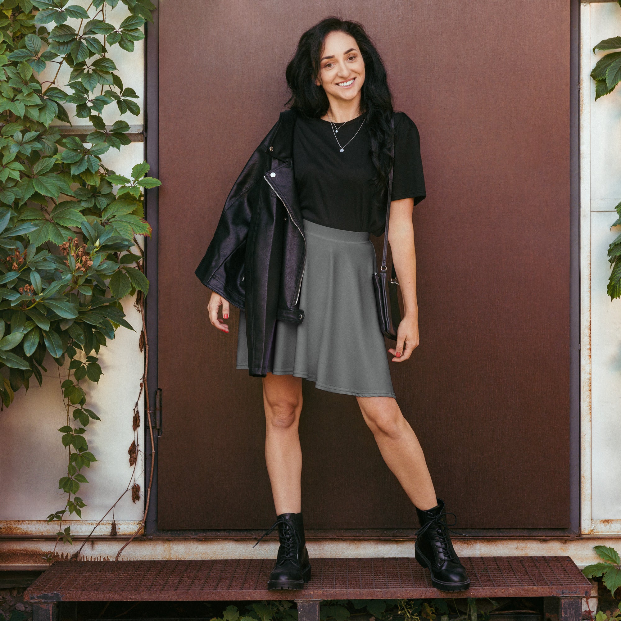Women’s gray skater skirt with flowy high waisted fit made from recycled fabric with upf 50 plus protection and black leather jacket with zipper details