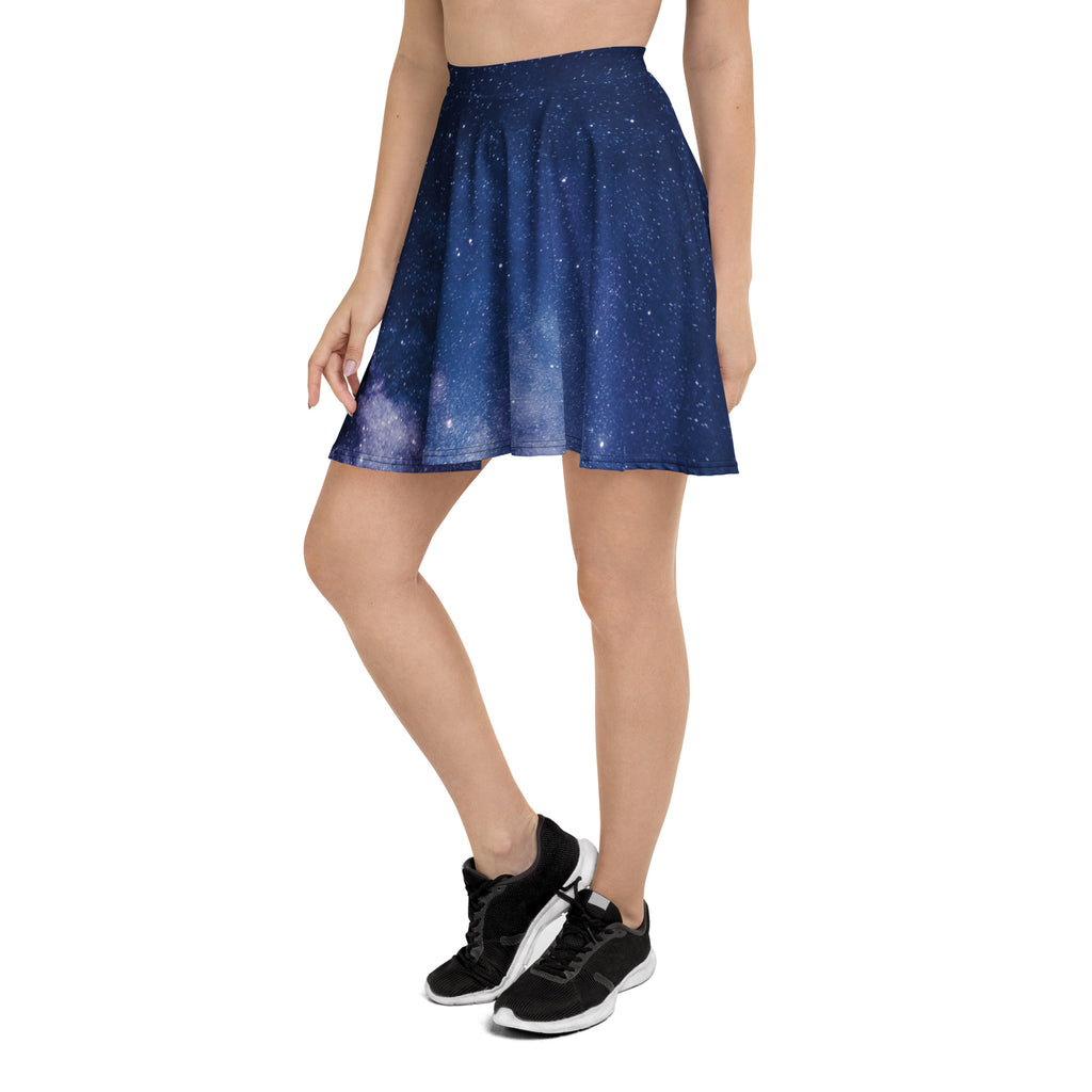 A navy blue pleated high waisted skater skirt with a gradient starry night sky print made from recycled fabric