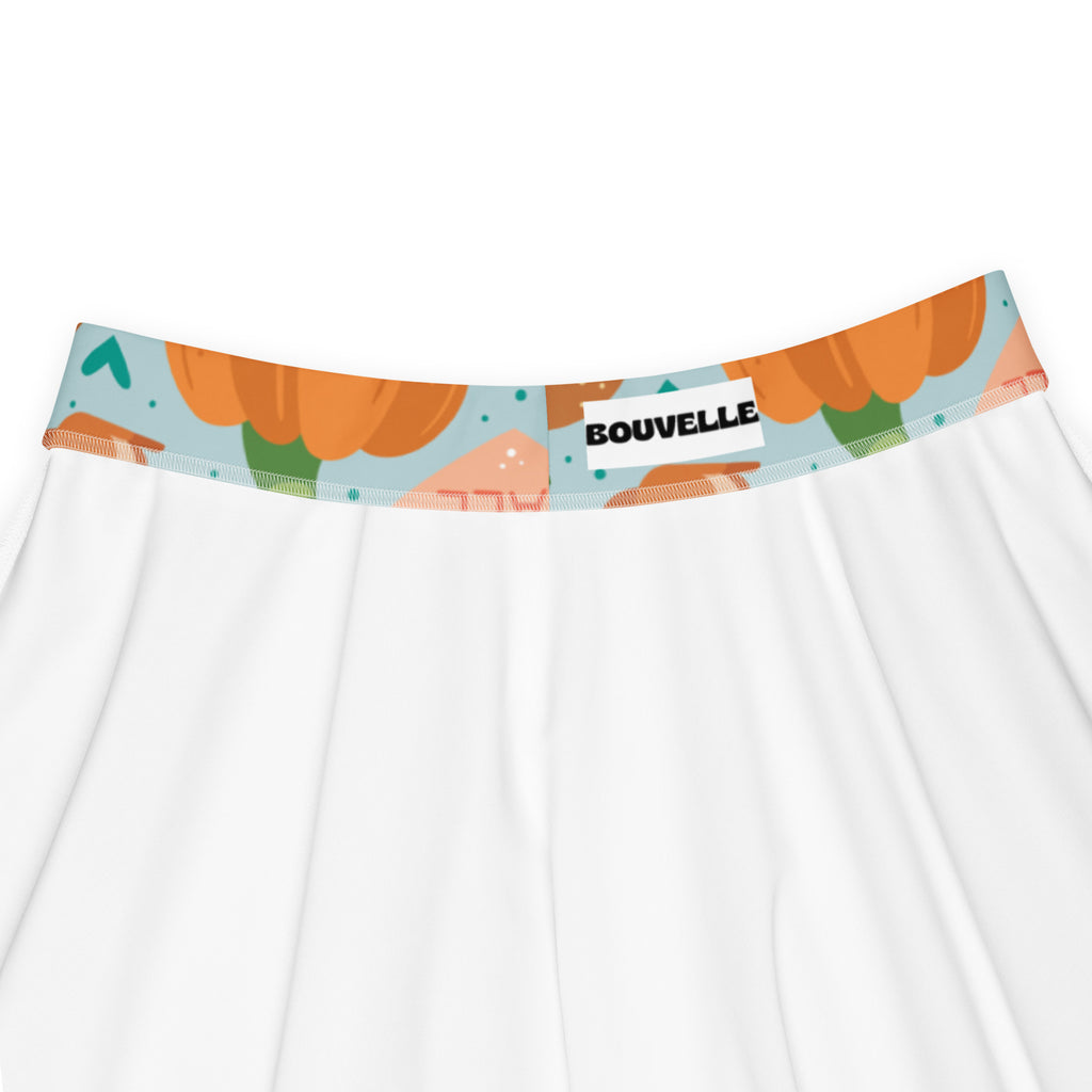 White women’s underwear with playful orange pumpkin pattern on elastic waistband against light blue background