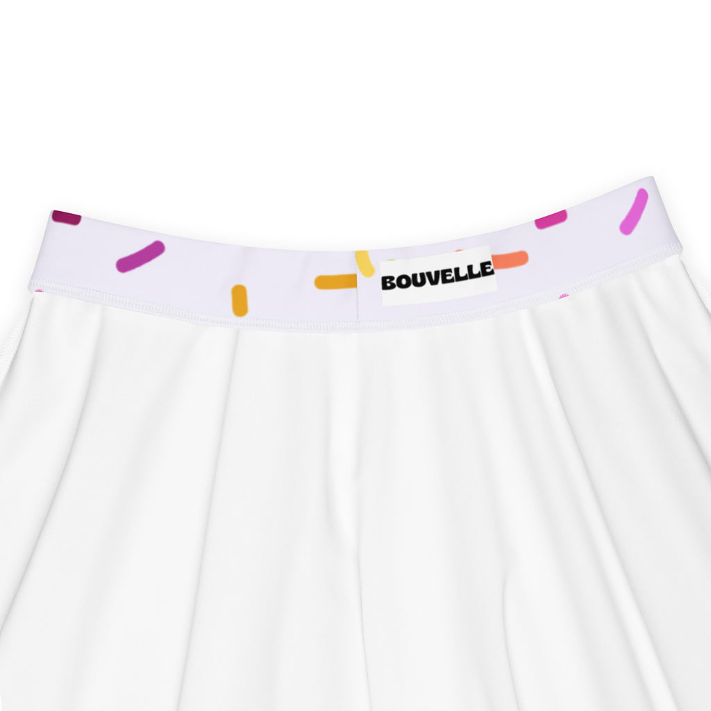 White pleated skater skirt with colorful sprinkle waistband and bouvelle label made from recycled fabric with upf 50+