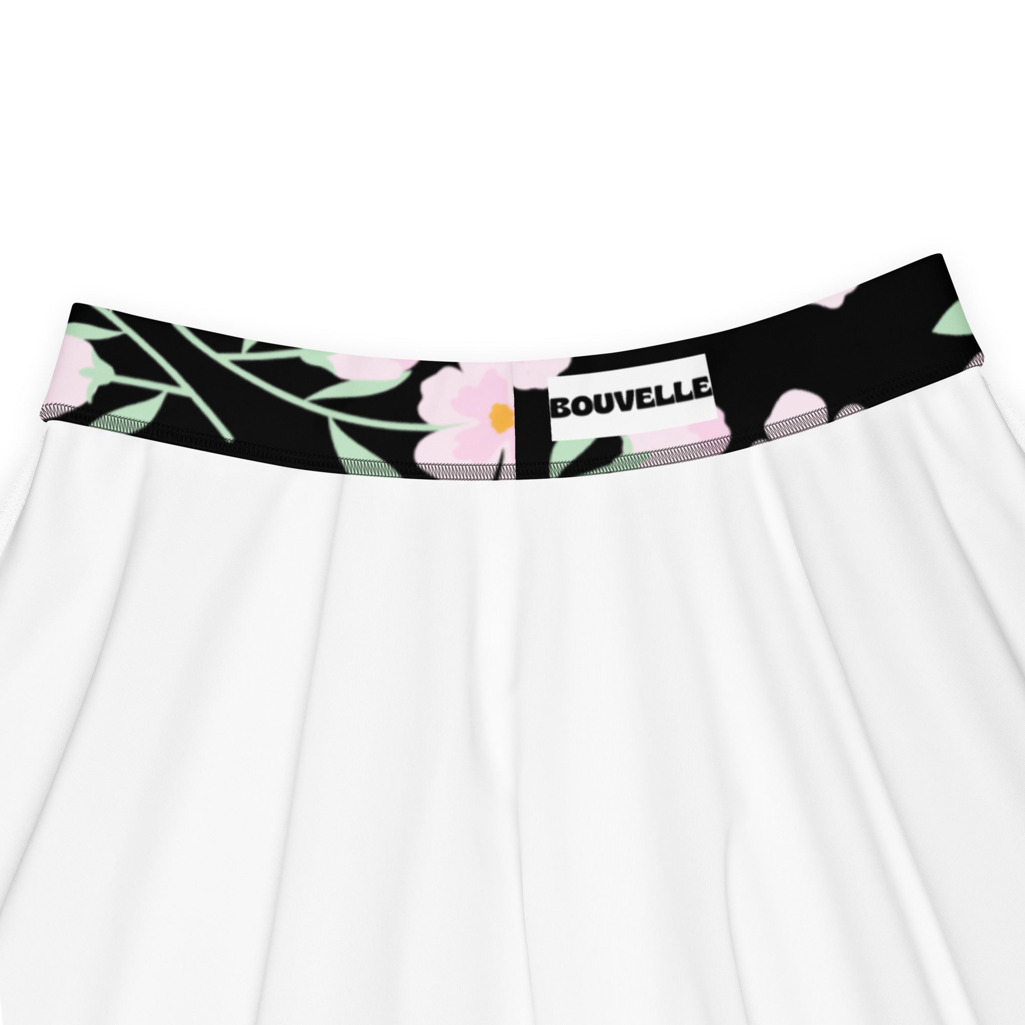White skirt with black waistband featuring pink floral and green leaf patterns branded bouvelle made with recycled fabric