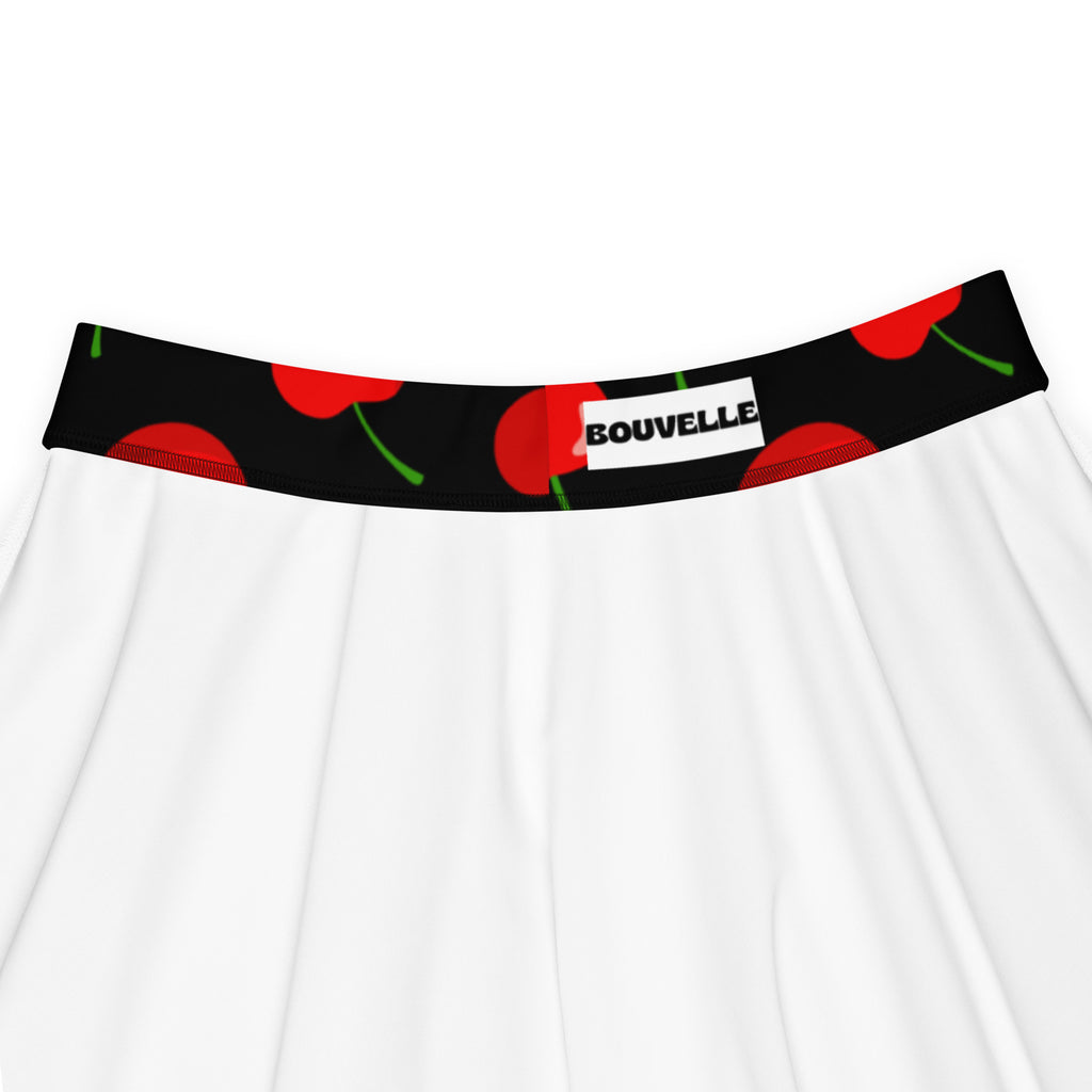 White skirt with black waistband, red cherry prints, green stems, bouvelle label, high waisted skater skirt with upf 50+