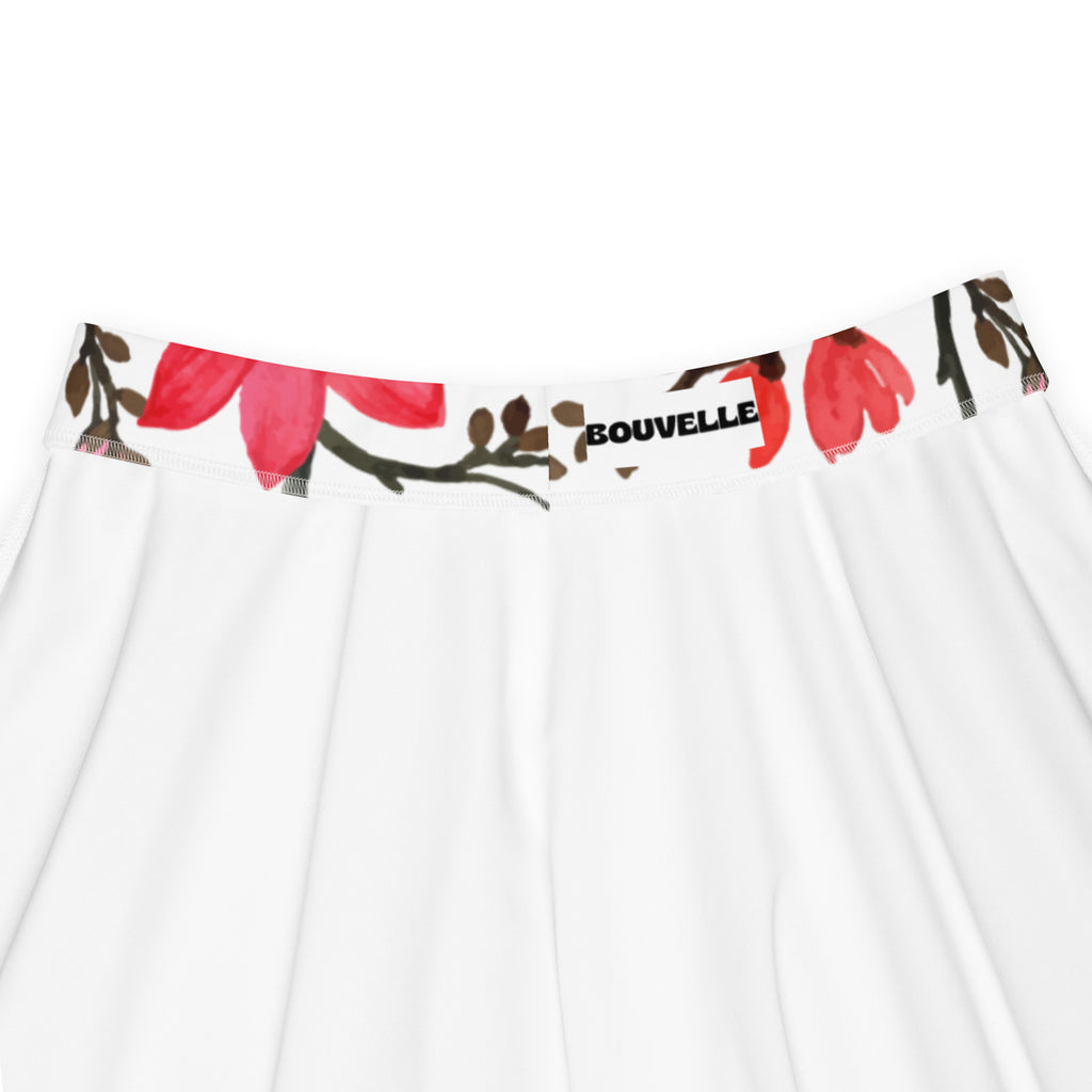 White skirt with vibrant red floral waistband featuring bouvelle label in a flowy high waisted skater style with recycled fabric