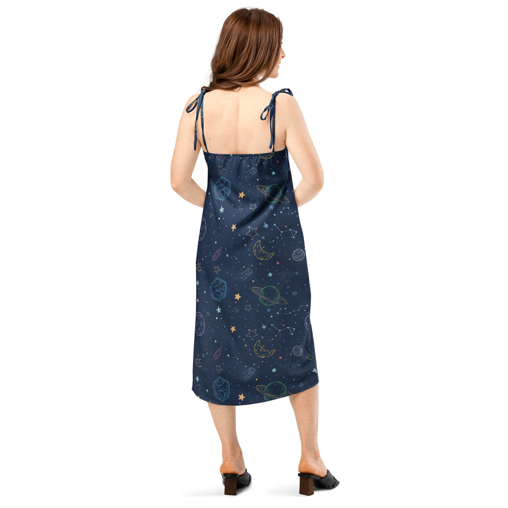 Woman wearing a navy blue dress with space-themed pattern on a white background