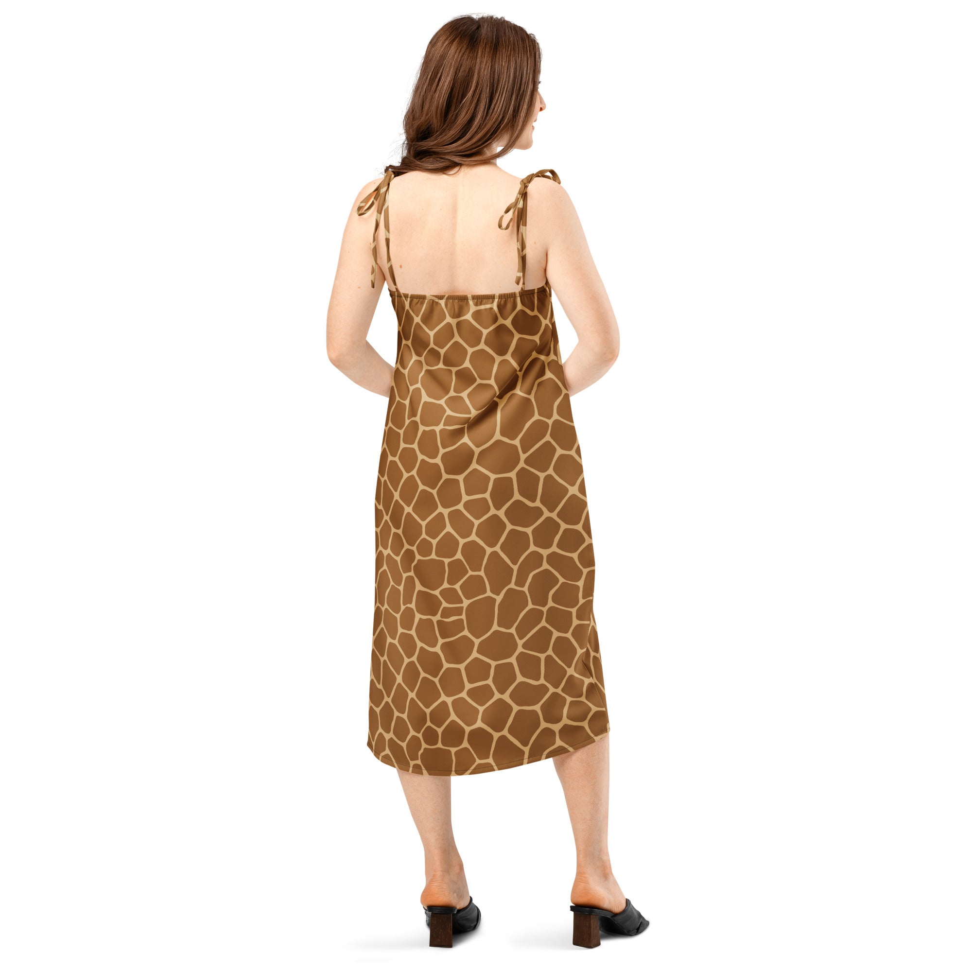 A woman wearing a brown giraffe print midi slip dress with thin adjustable tie back straps and built in bra