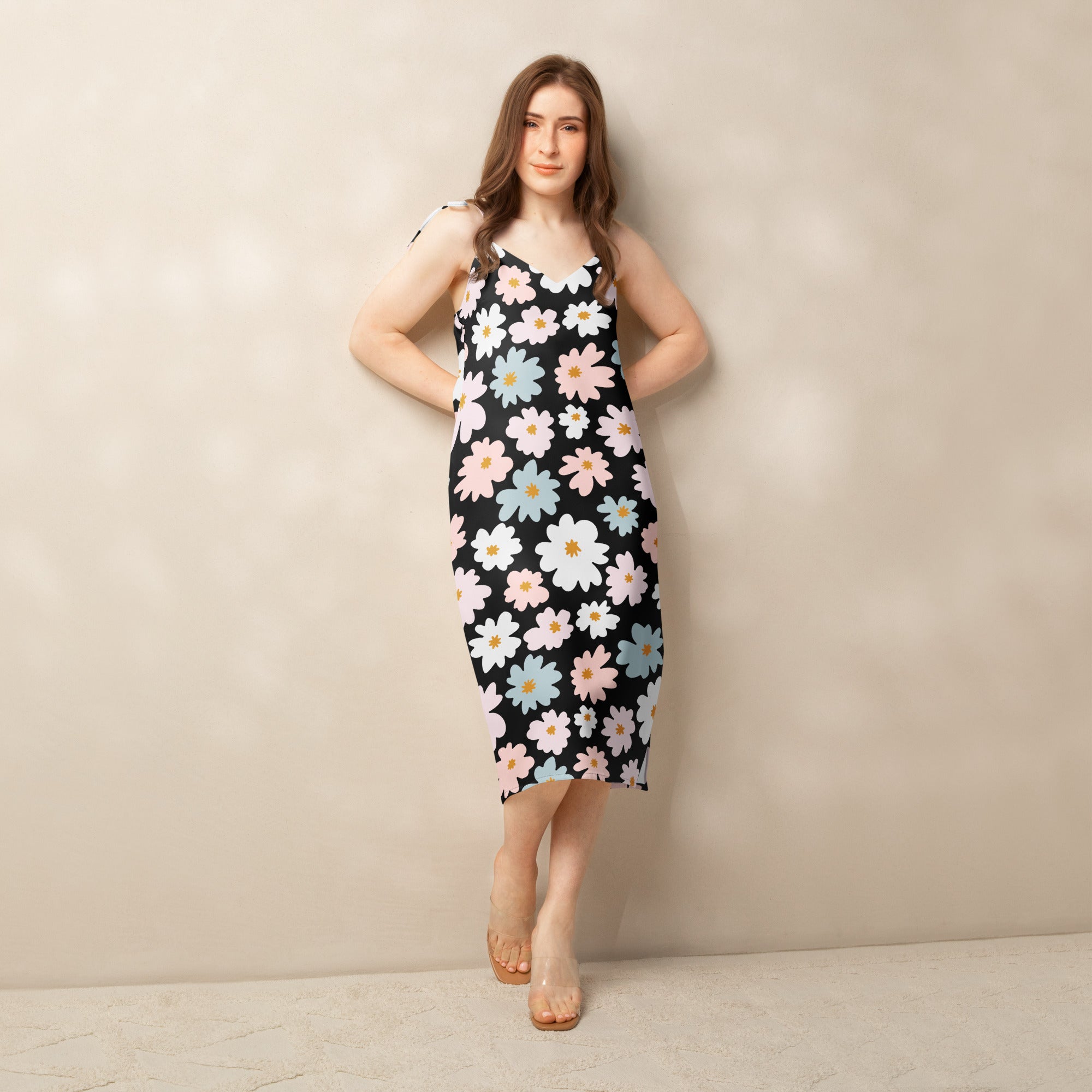 A black sleeveless midi dress with vibrant pink white and light blue floral pattern and adjustable tie straps