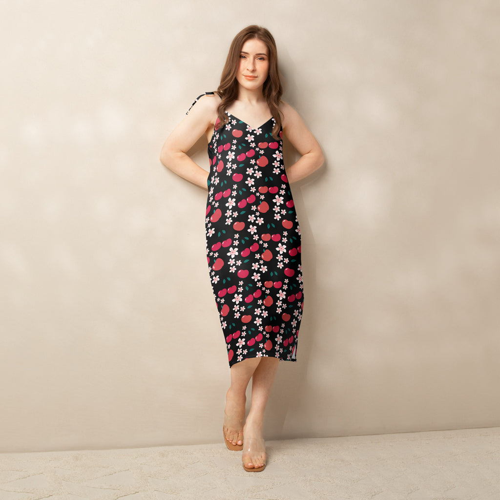 Women’s black spaghetti strap midi slip dress with vibrant pink cherry and white blossom pattern and adjustable tie straps