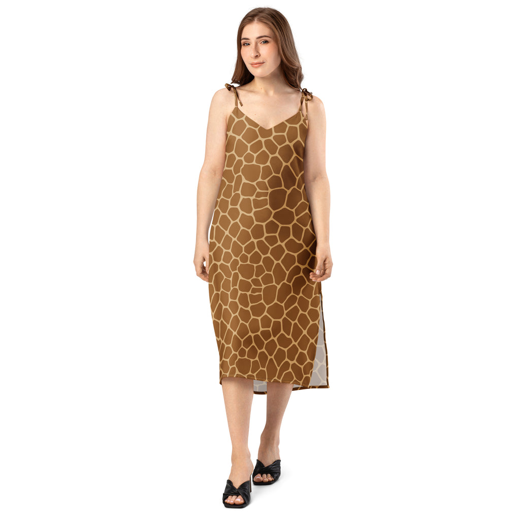 A women’s mid-calf slip dress with brown and tan giraffe print and adjustable spaghetti straps tied at the shoulders