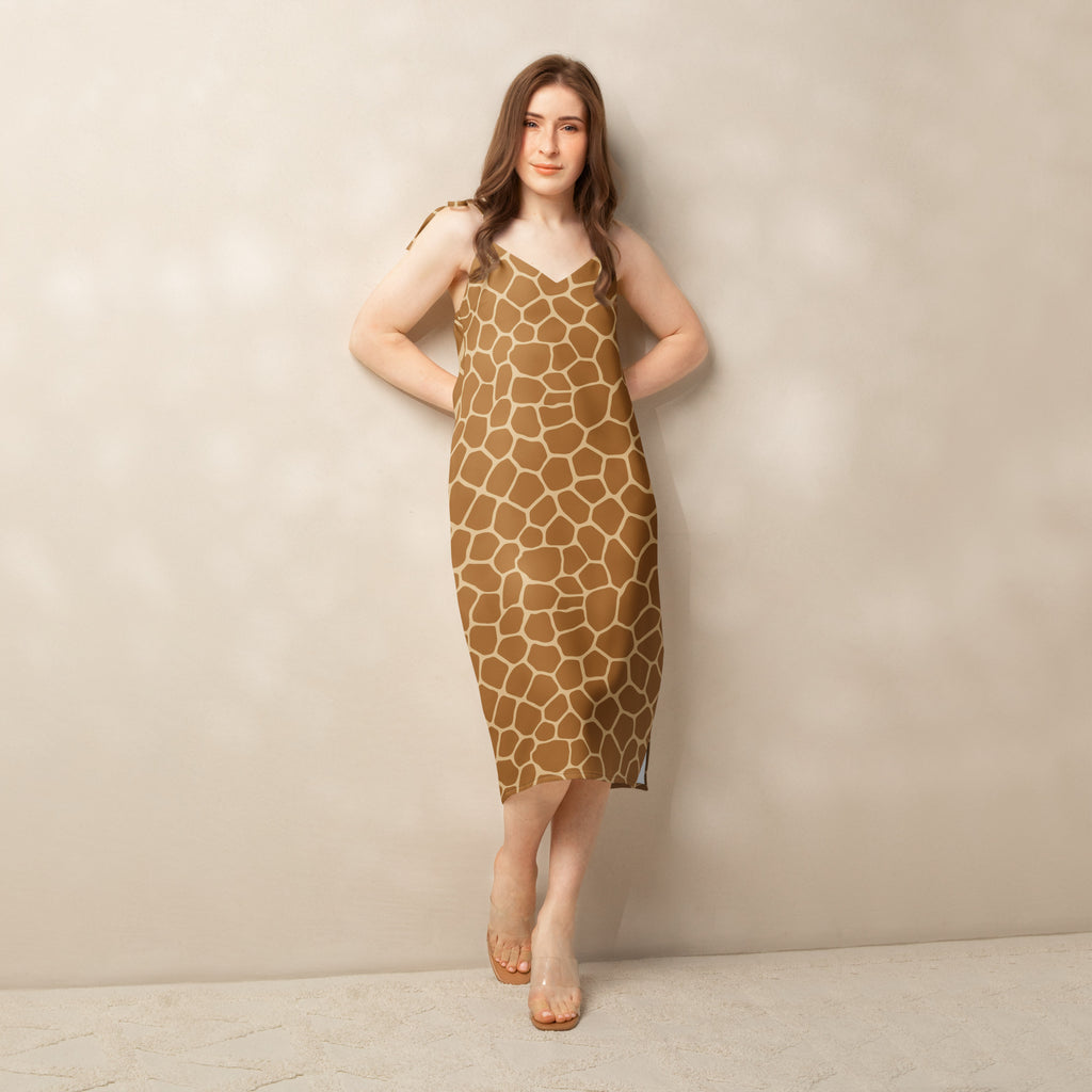 A woman wears a women’s giraffe print slip dress with adjustable tie straps and built in bra in tan and beige