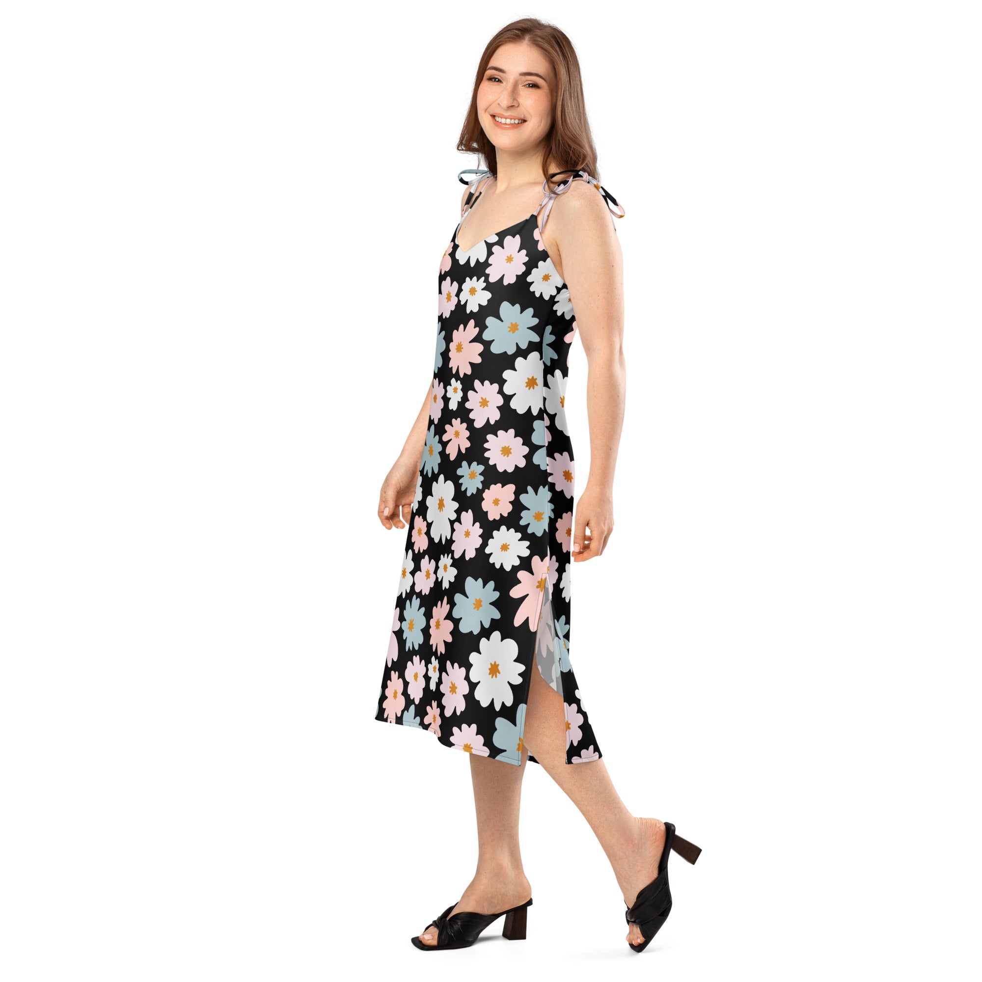 A black sleeveless midi slip dress with vibrant pink white and blue daisy floral pattern and adjustable tie straps