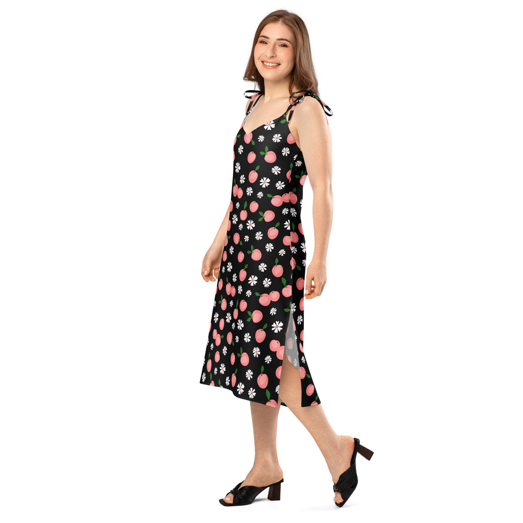 Black sleeveless midi slip dress with peach pink white daisy prints, adjustable tie straps, side slit, and built-in bra