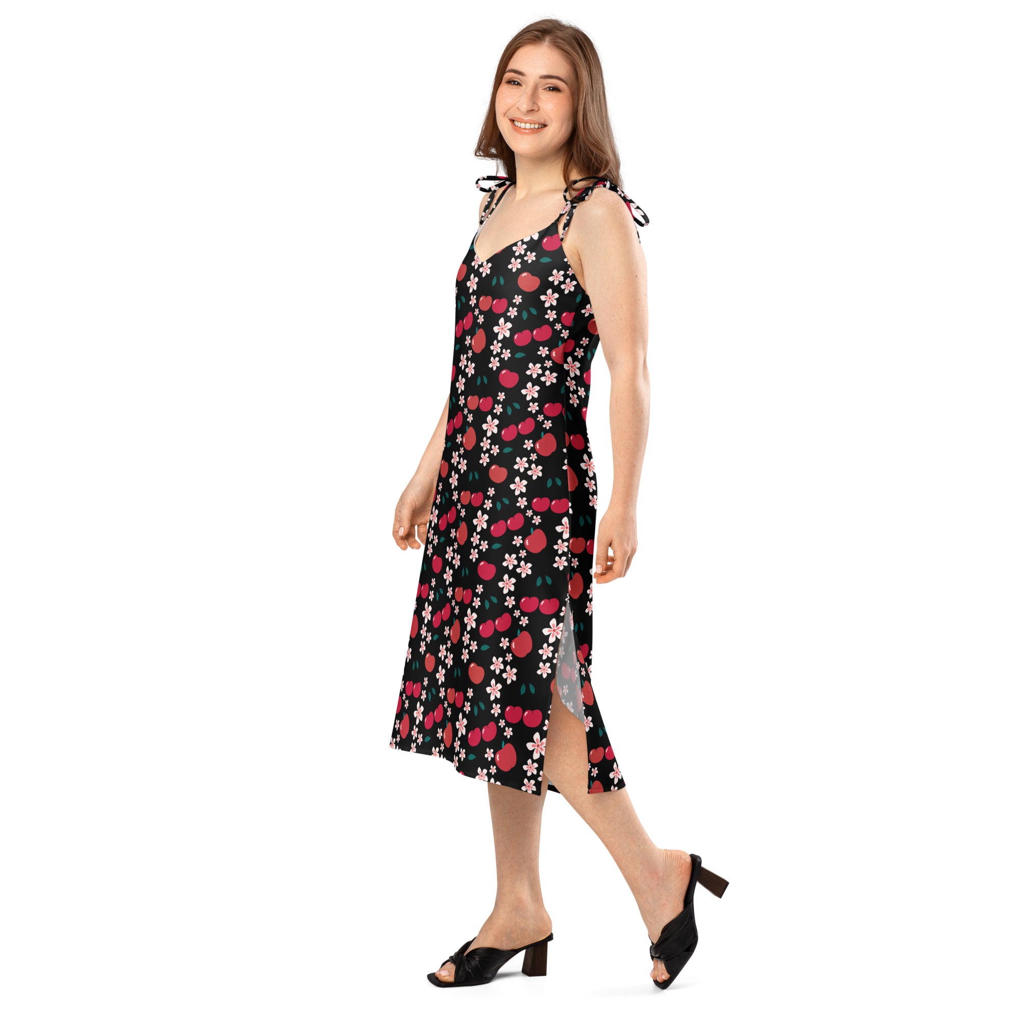 A black sleeveless midi dress with vibrant red cherry and pink blossom pattern and adjustable tie straps