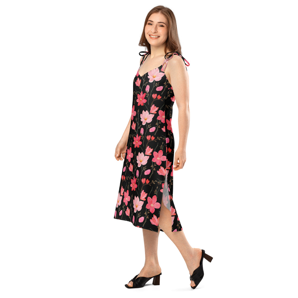 Women’s black floral print midi slip dress with pink and red blossoms, adjustable tie straps, side slit, and flowing silhouette