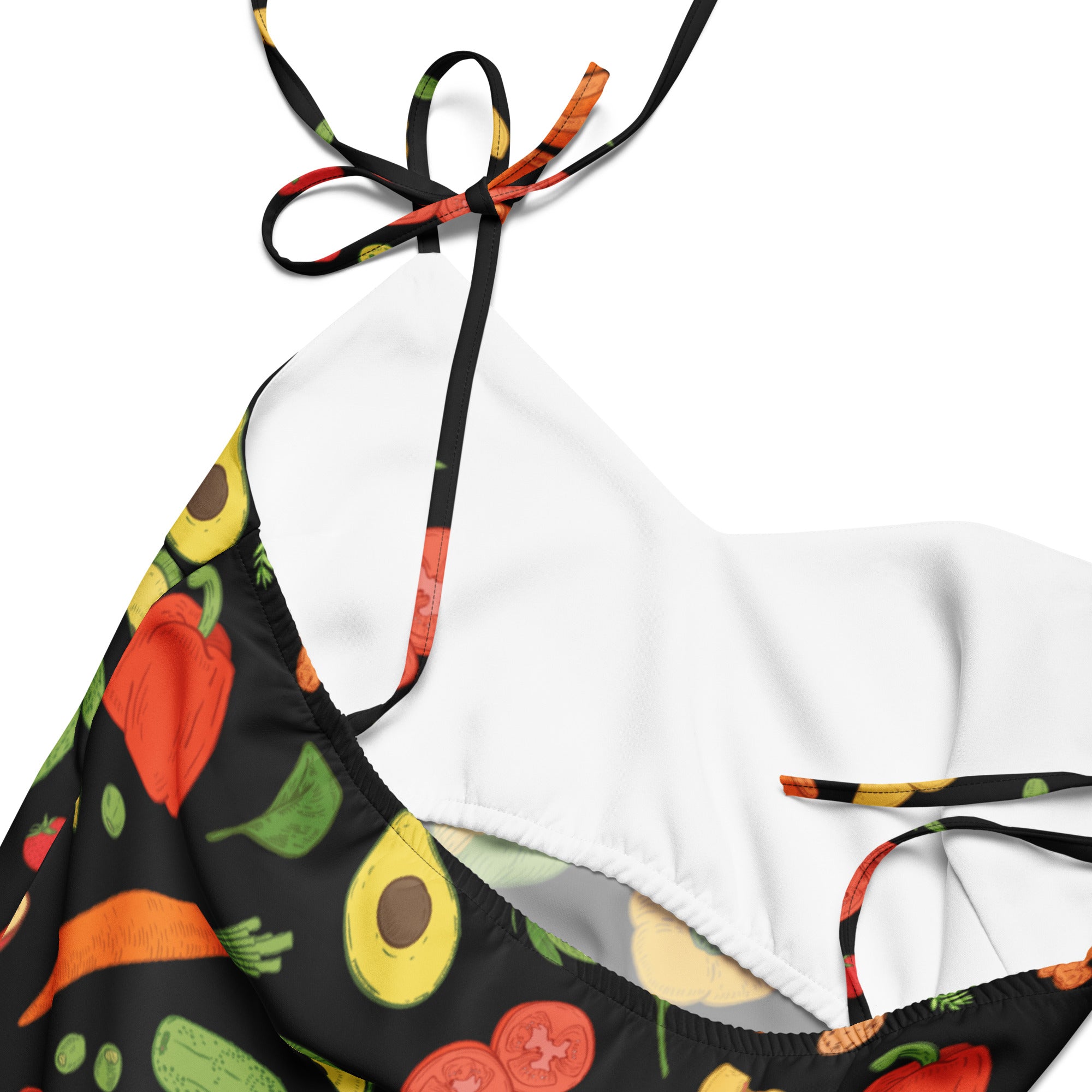 Black halter top bikini with vibrant vegetable print and white interior lining complementing women’s vegetable and fruit slip dress