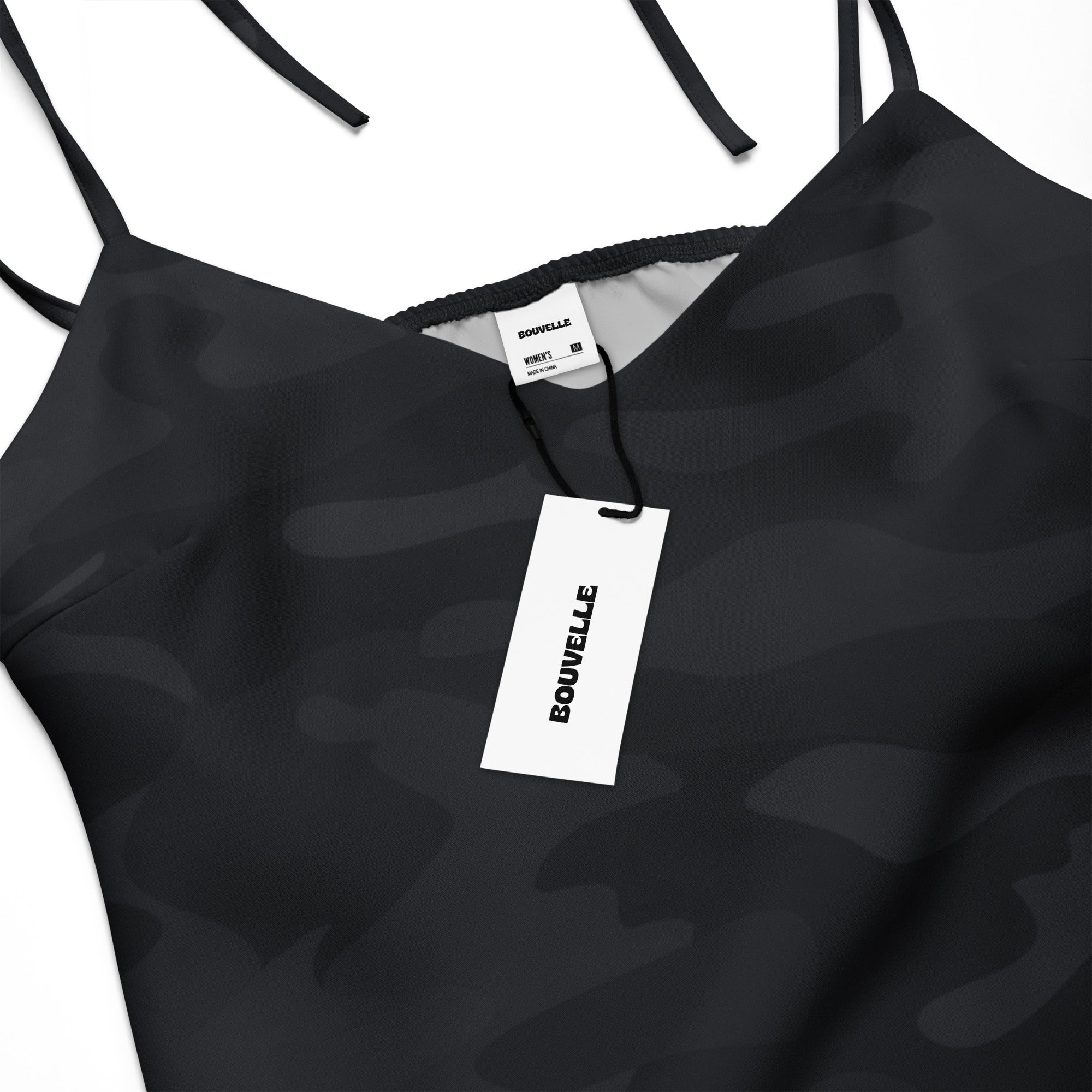 Women’s black camouflage slip dress with adjustable tie spaghetti straps and branded tags showcasing sleek design