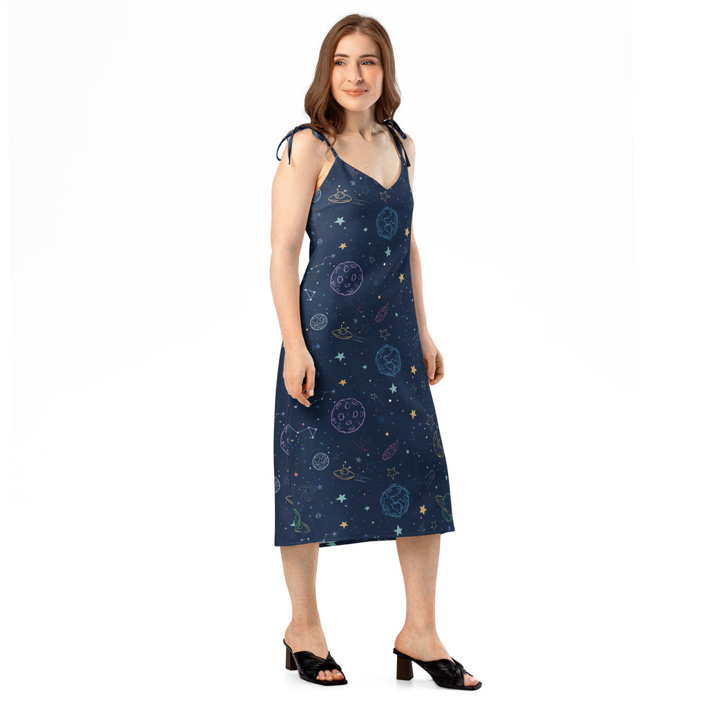 Woman wearing a navy blue dress with space-themed pattern on a white background