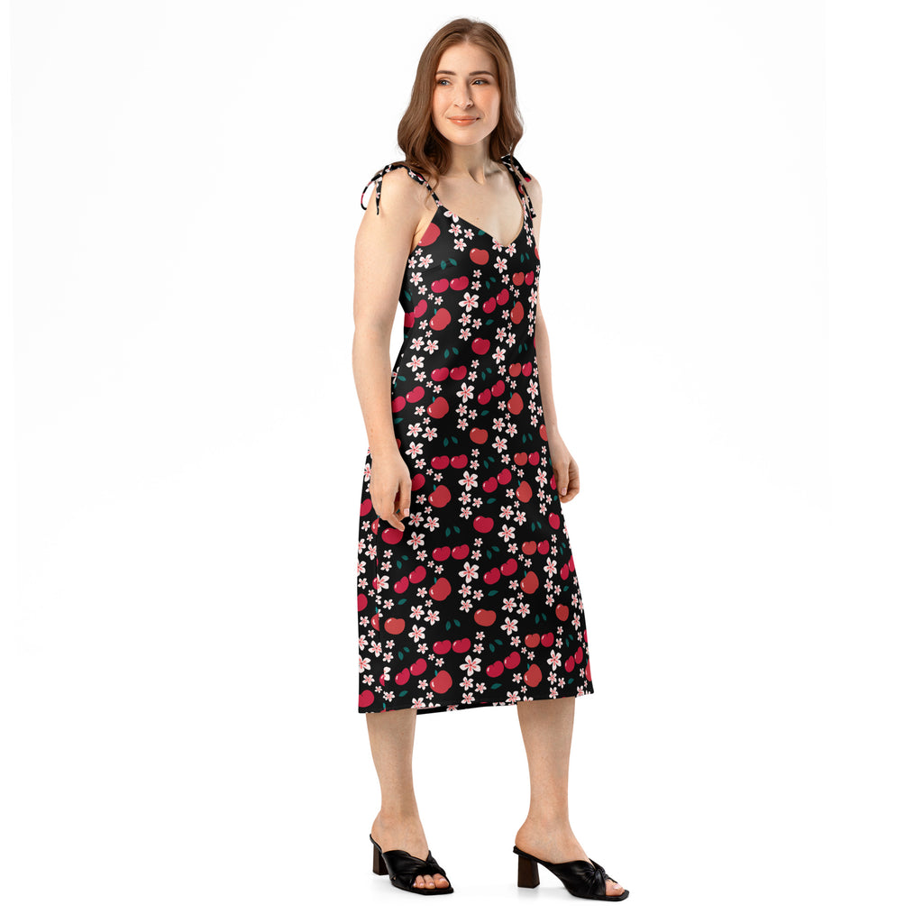 Women’s black sleeveless midi slip dress with red cherry and pink blossom pattern and adjustable tie straps