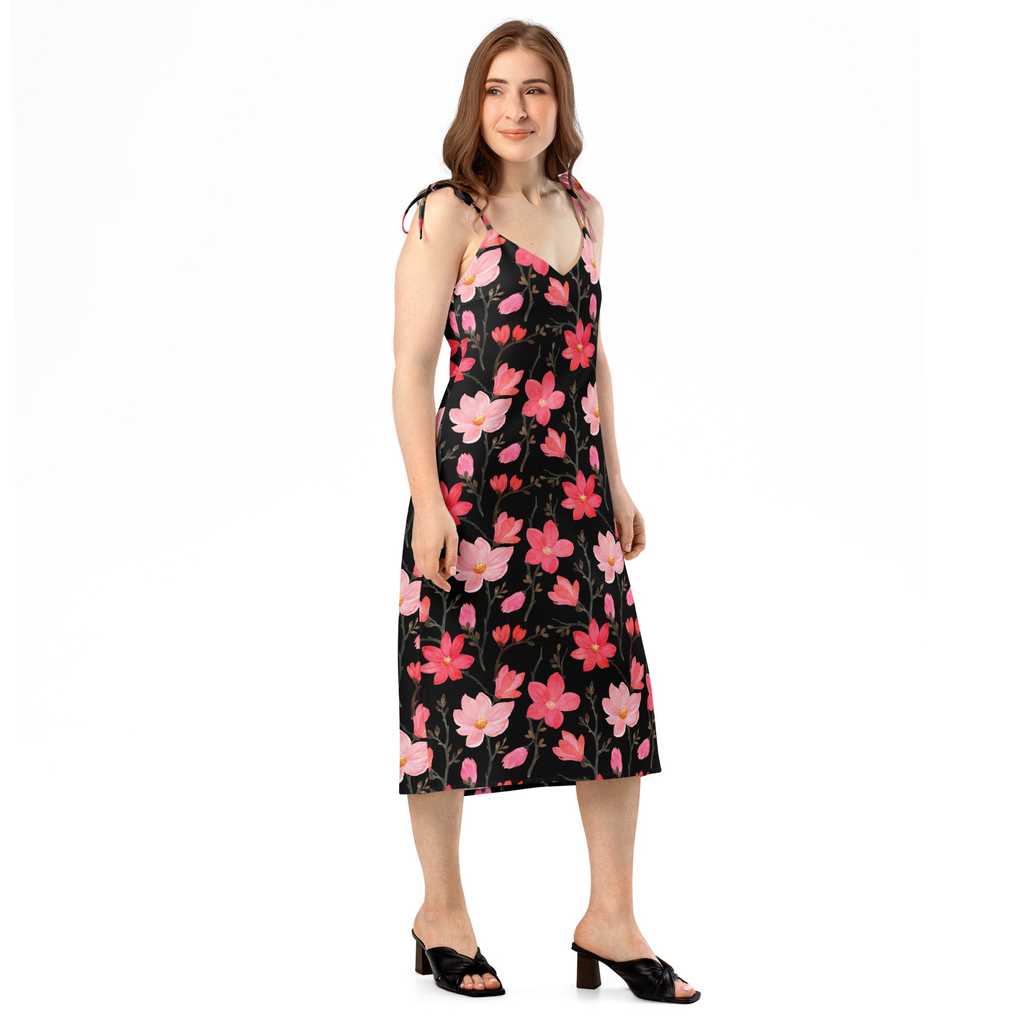 A black floral midi slip dress with pink blossoms and adjustable tie straps featuring a built in bra