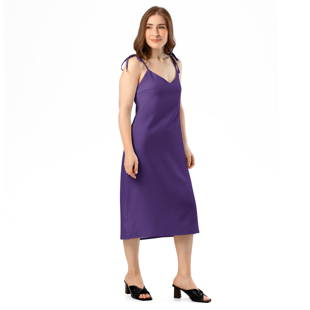 Woman wearing a purple dress with white patterns on a white background