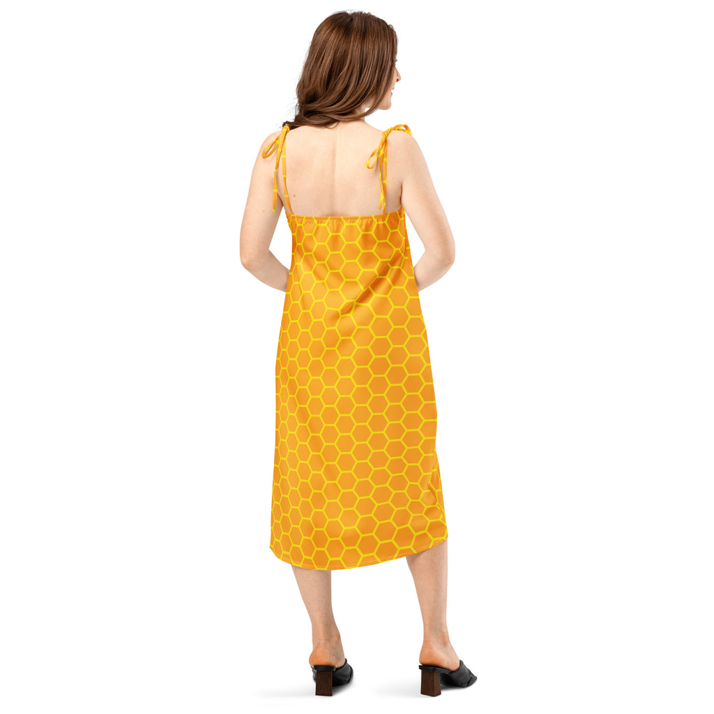 A vibrant yellow midi dress with bold honeycomb pattern and delicate tie-back straps shown from the back