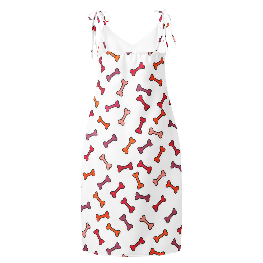 White sleeveless midi slip dress with adjustable tie straps and colorful red orange pink dog bone pattern with built in bra