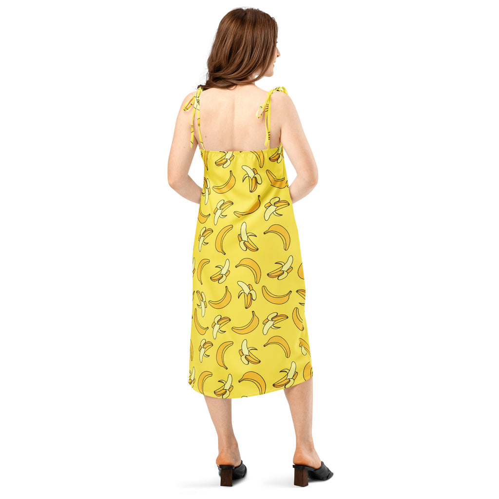 Woman wearing a yellow dress with banana pattern on a white background