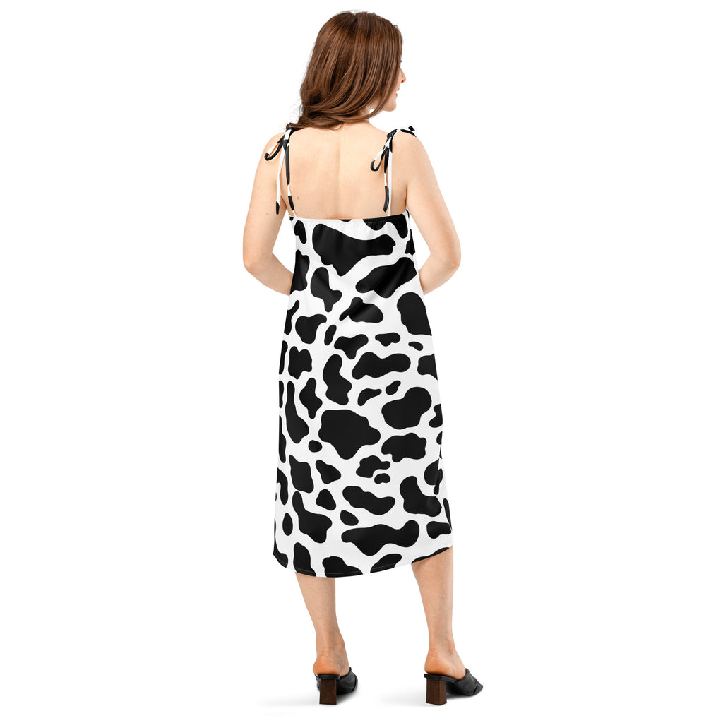 Woman wearing a black and white cow print dress on a white background