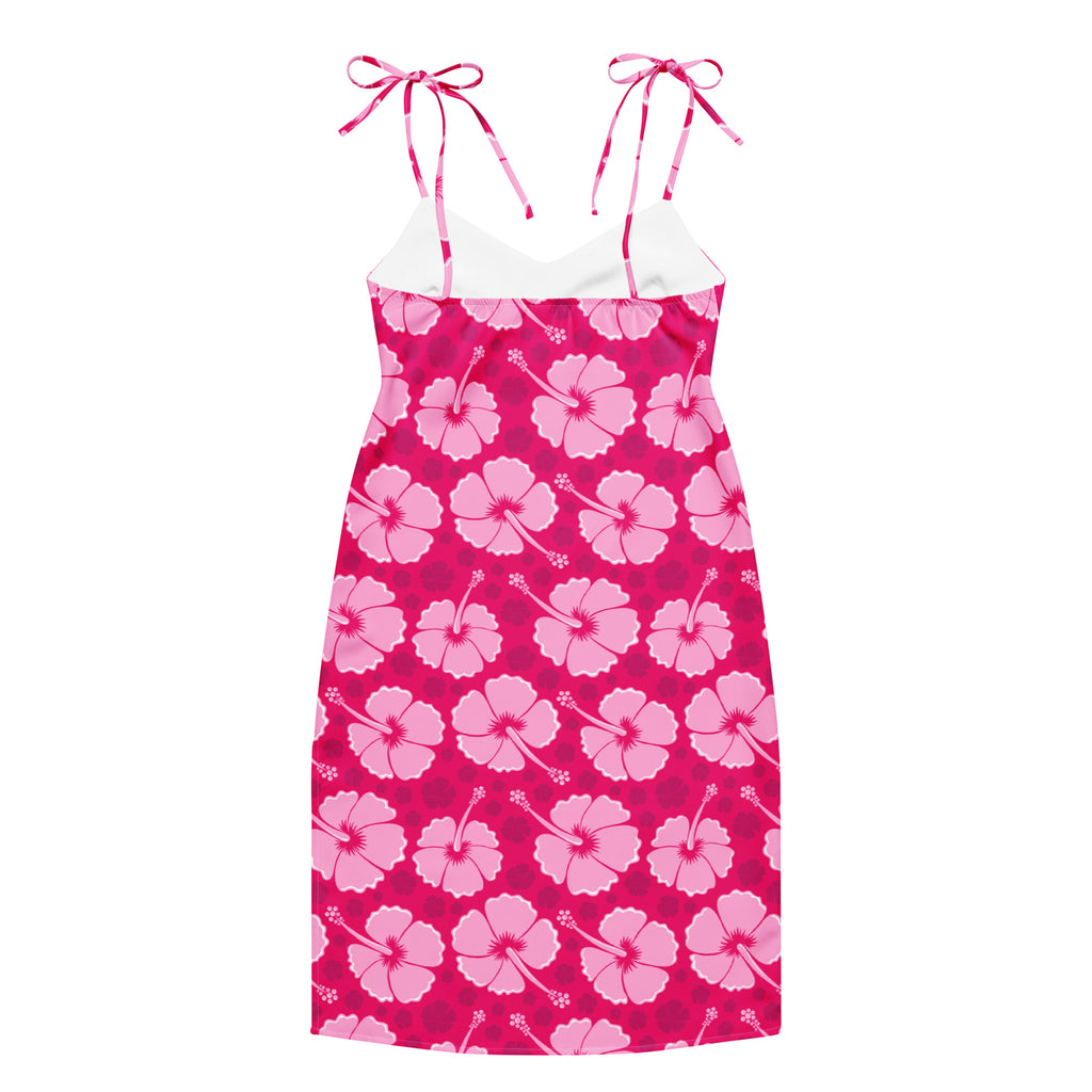 A vibrant pink hibiscus patterned women’s tropical slip midi dress with adjustable tie straps and a white underlayer