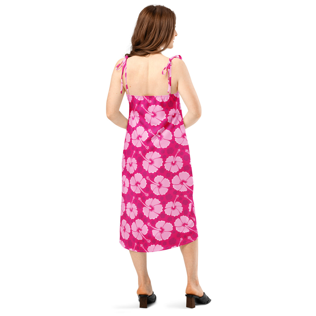 A vibrant pink midi slip dress with light pink hibiscus pattern and adjustable tie-back straps for women