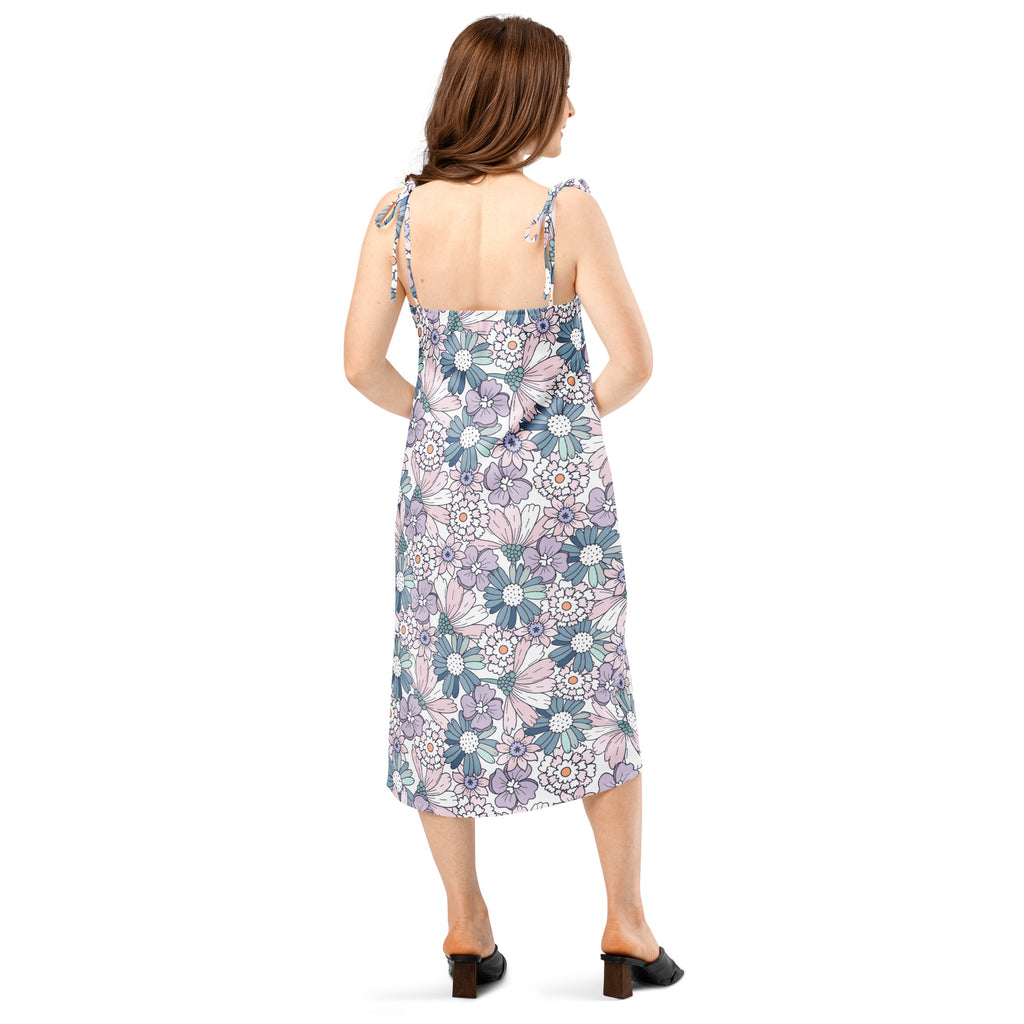 A woman wears a women’s pastel floral slip midi dress with adjustable tie straps and built in bra in lavender and teal